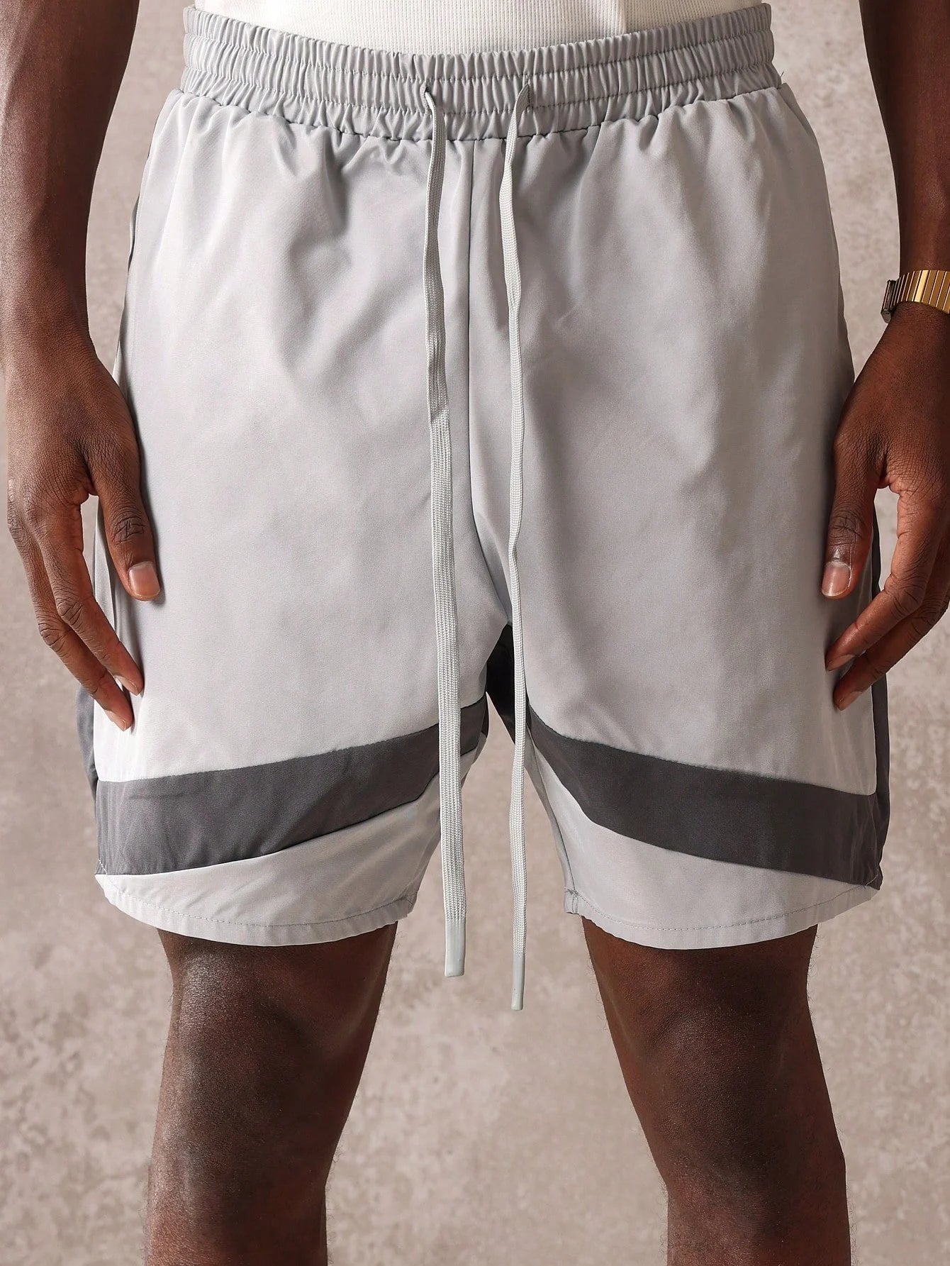 Grey shorts with a drawstring on a neutral background