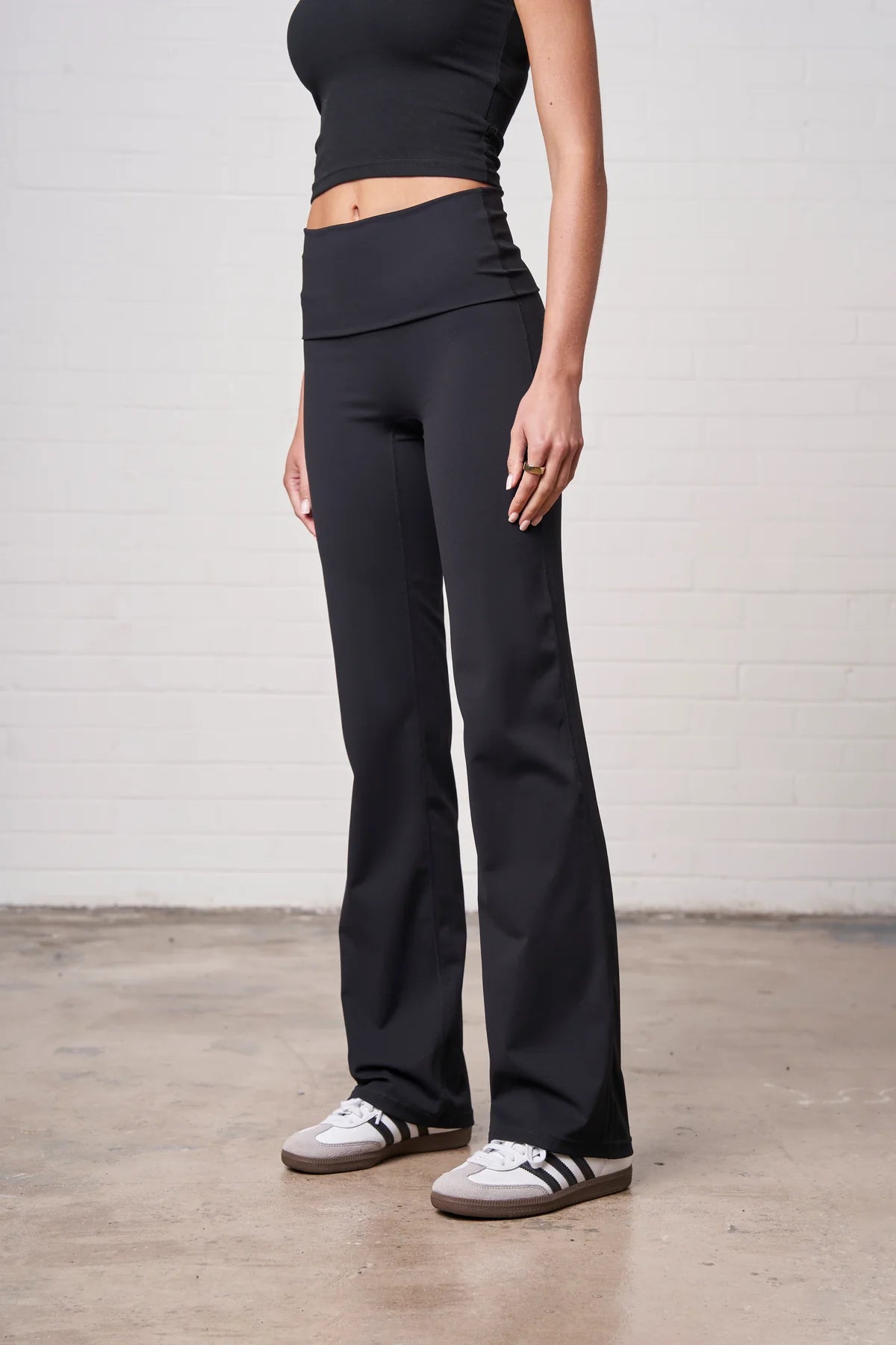 Person wearing black pants and a black top on a plain background