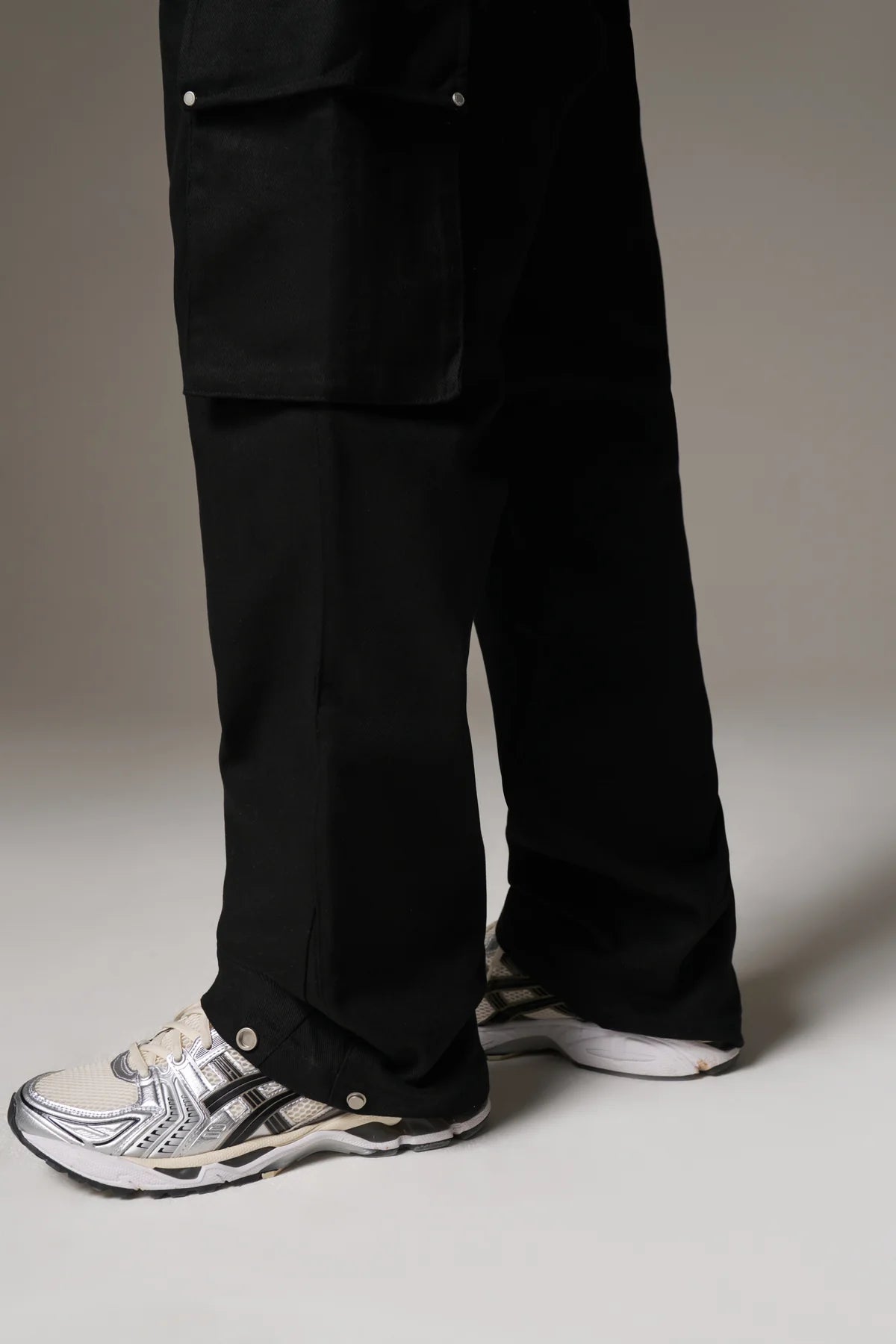 Black pants worn by a person on a grey background