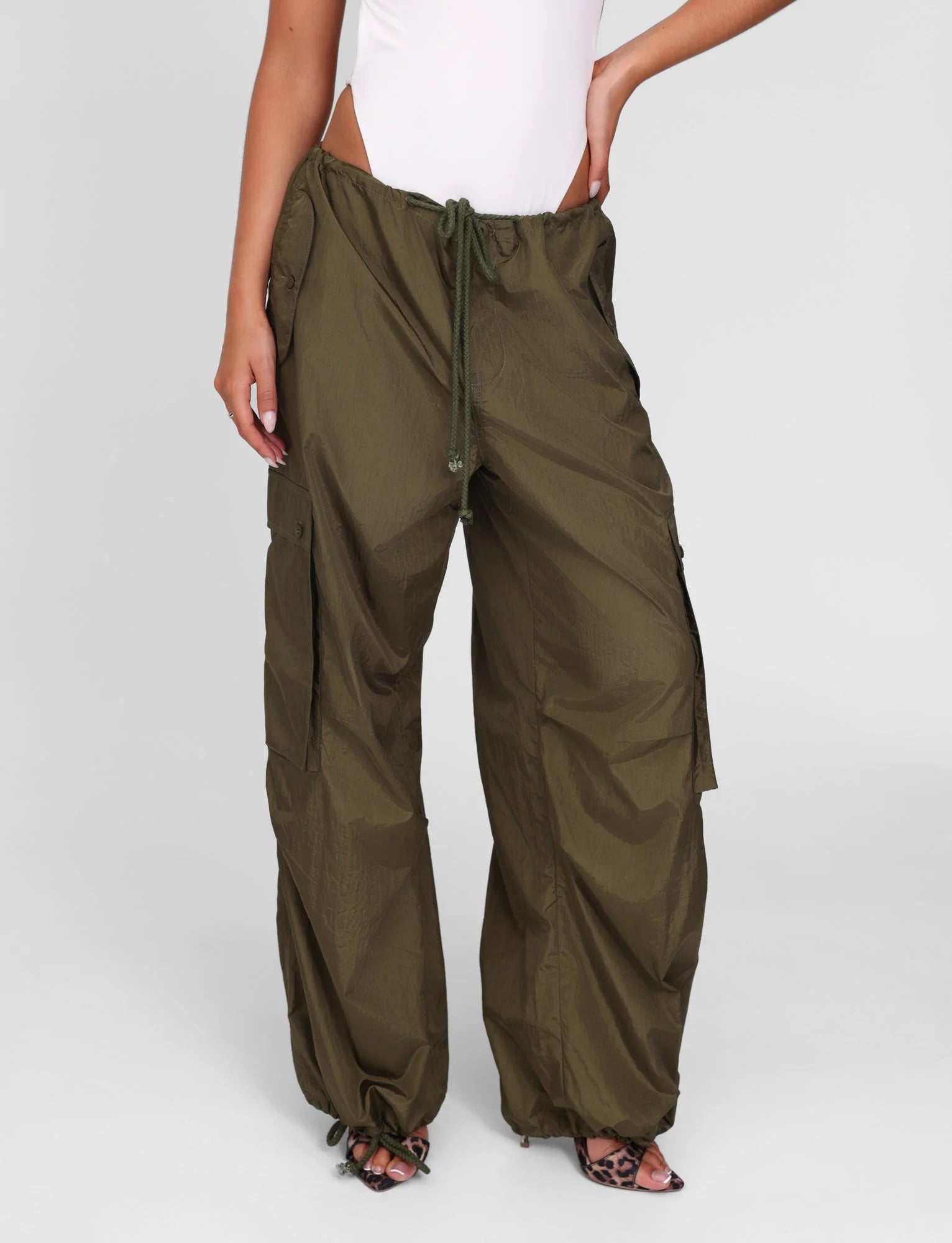 Person wearing olive green wide-leg pants on a white background