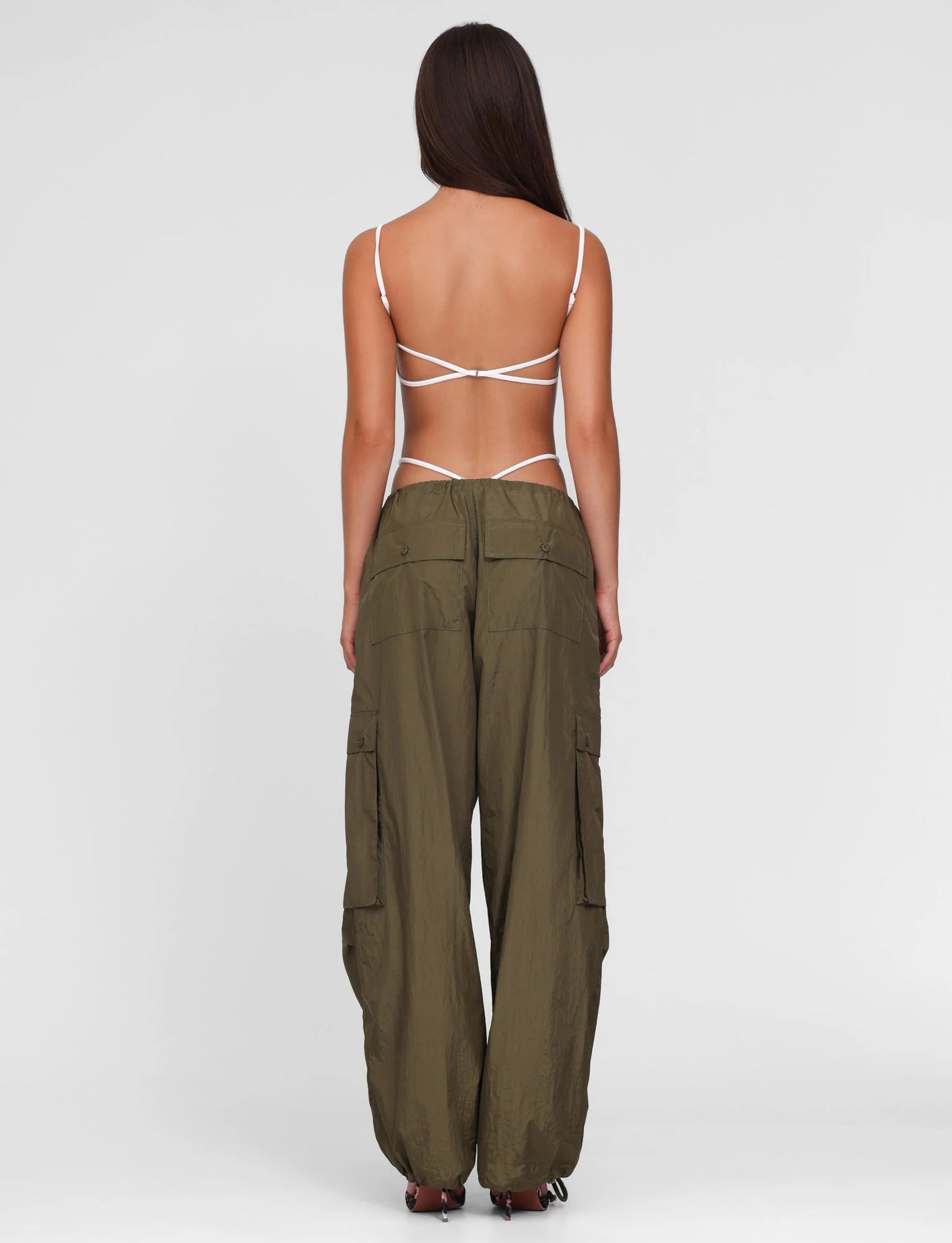 Person wearing olive green cargo pants on a white background