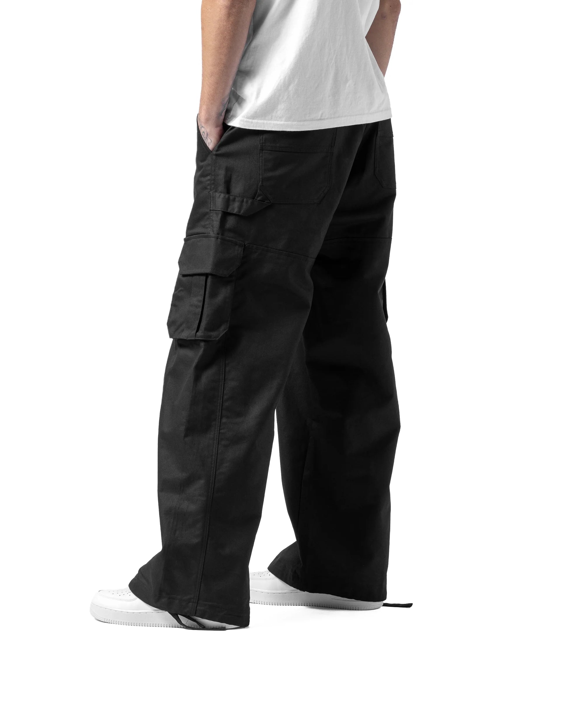 Person wearing black cargo pants on a white background