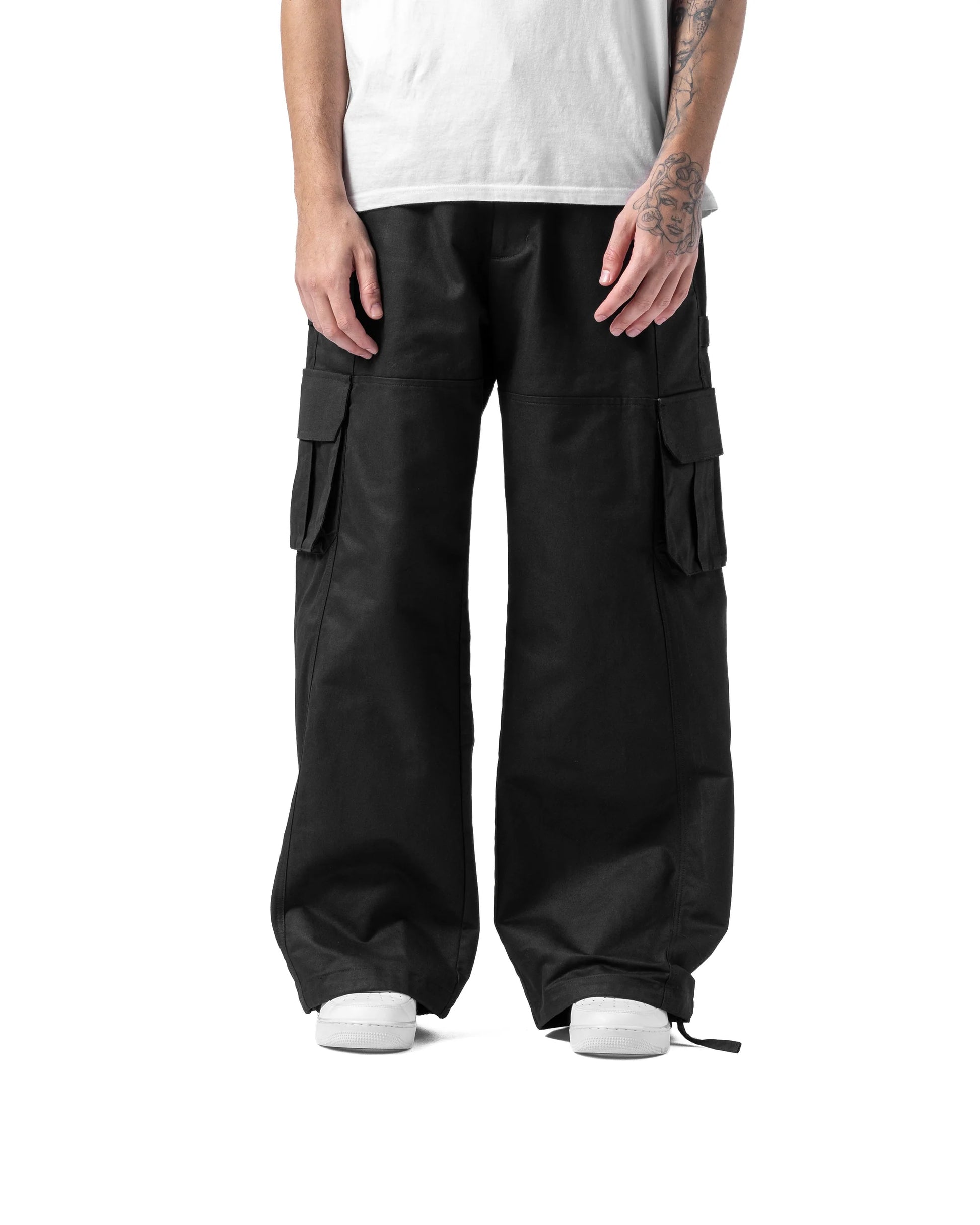 Person wearing black cargo pants on a white background