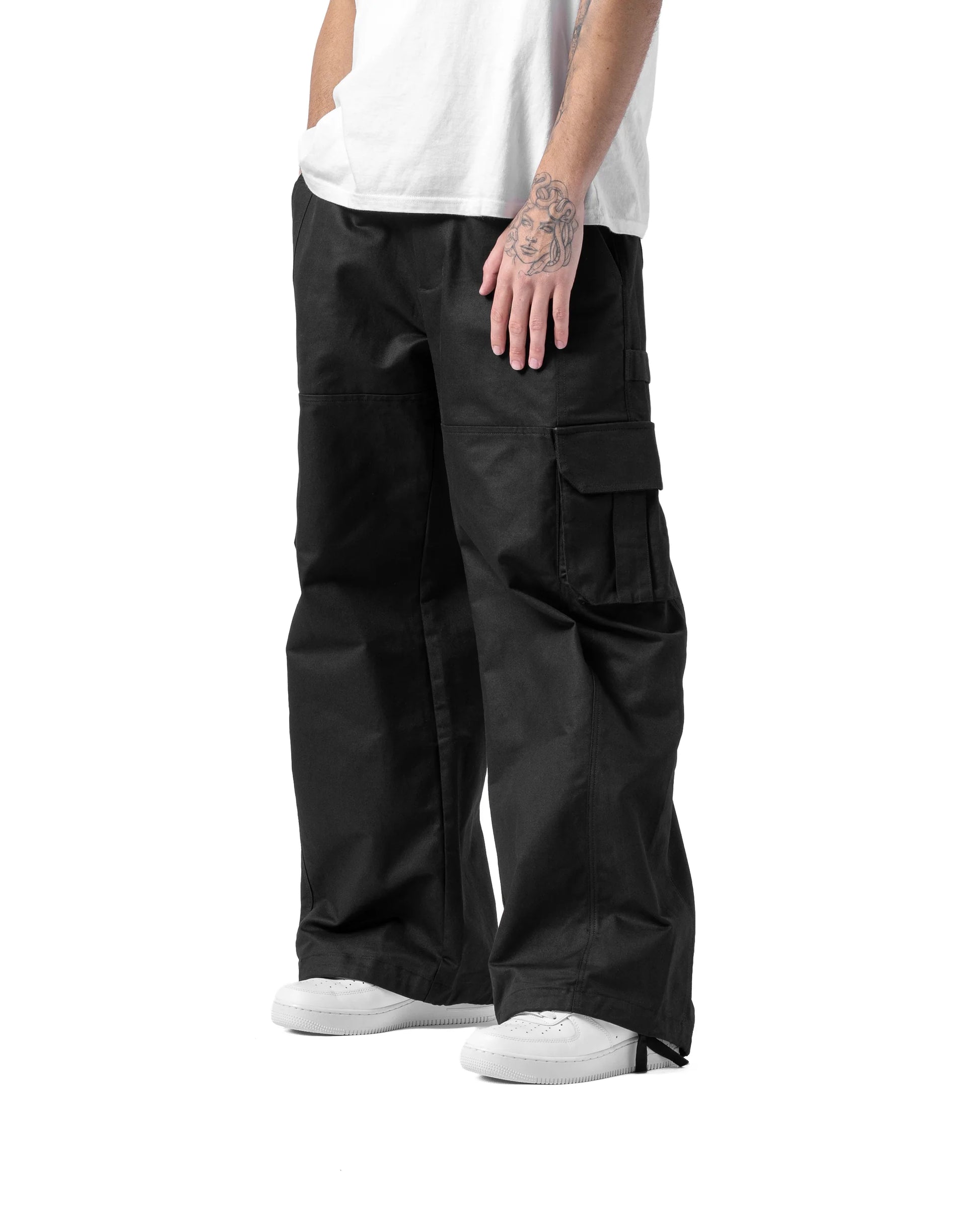 Person wearing black cargo pants on a white background