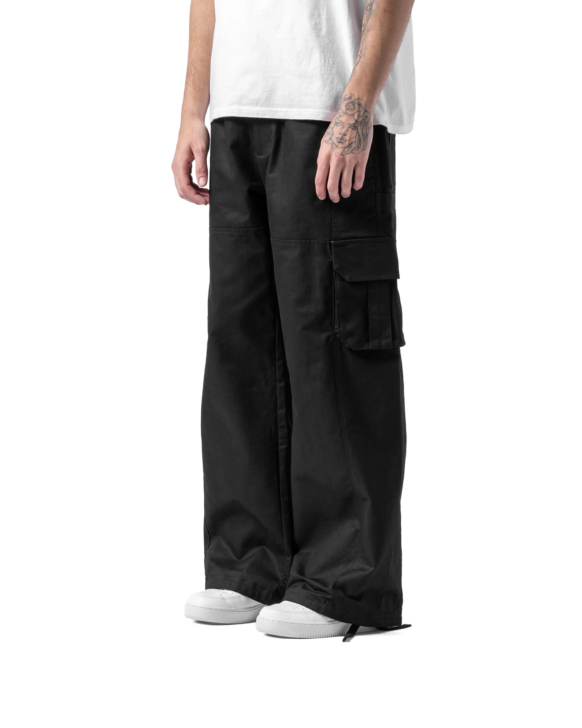 Person wearing black cargo pants and a white shirt on a white background