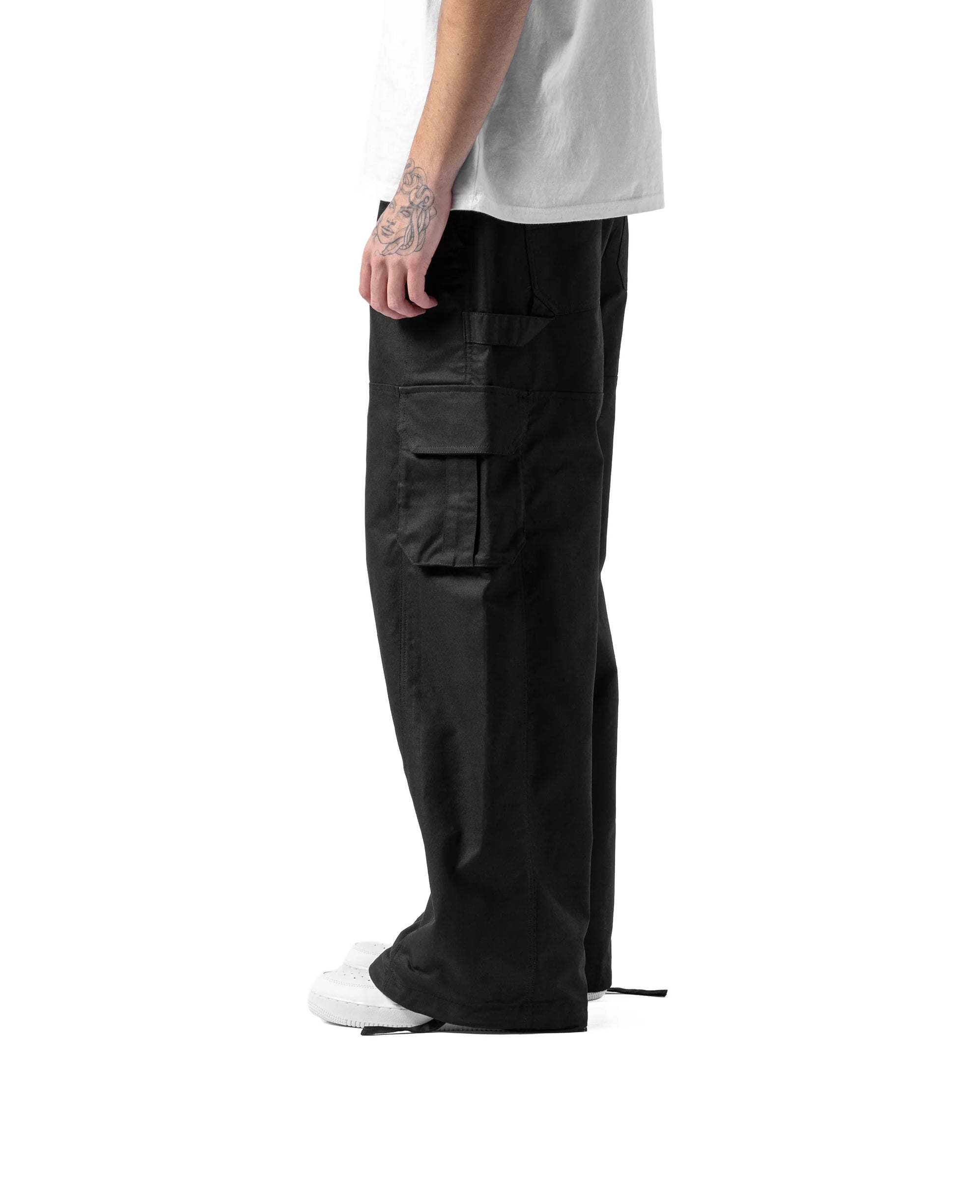 Person wearing black cargo pants on a white background