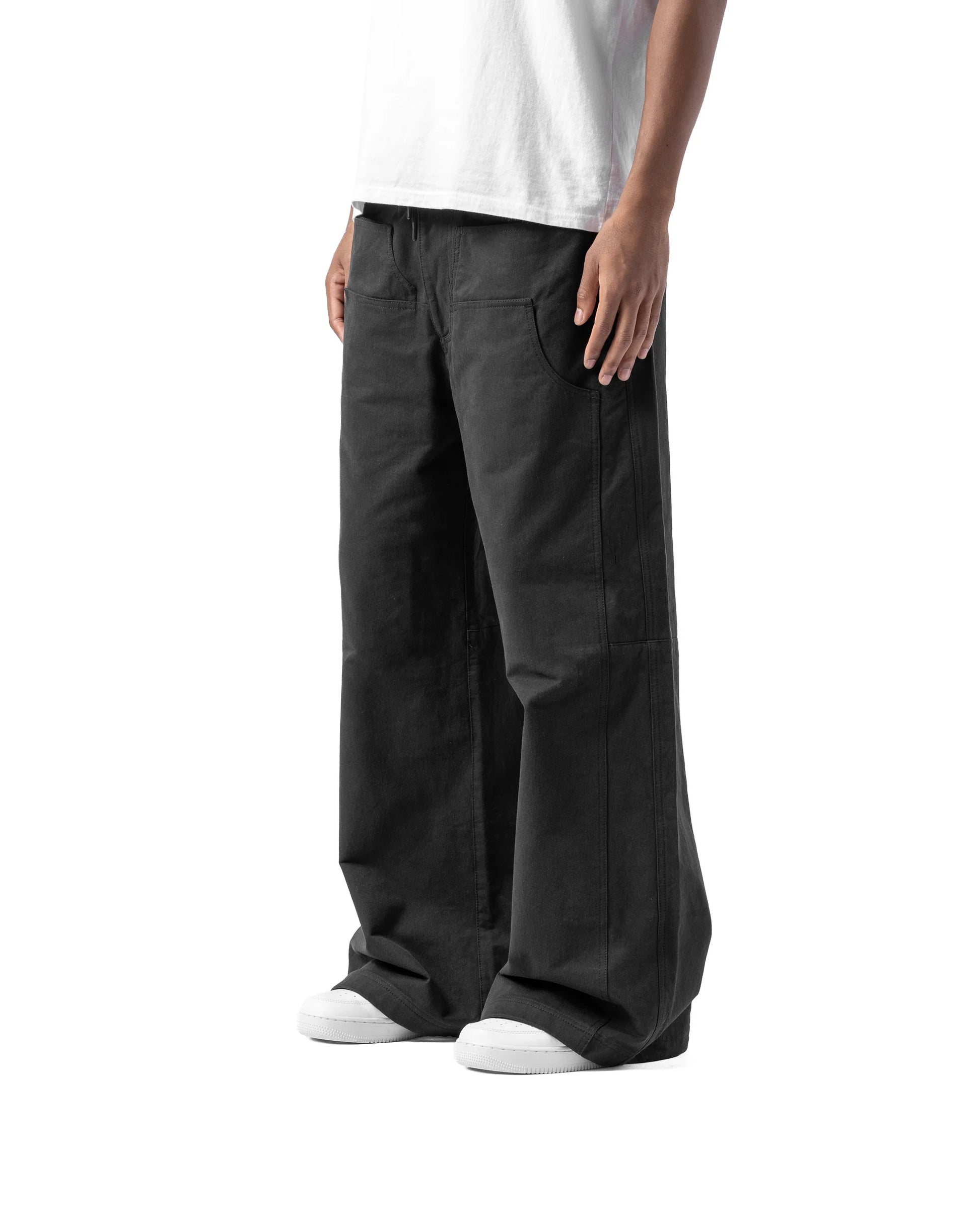 Person wearing black pants and a white t-shirt on a white background
