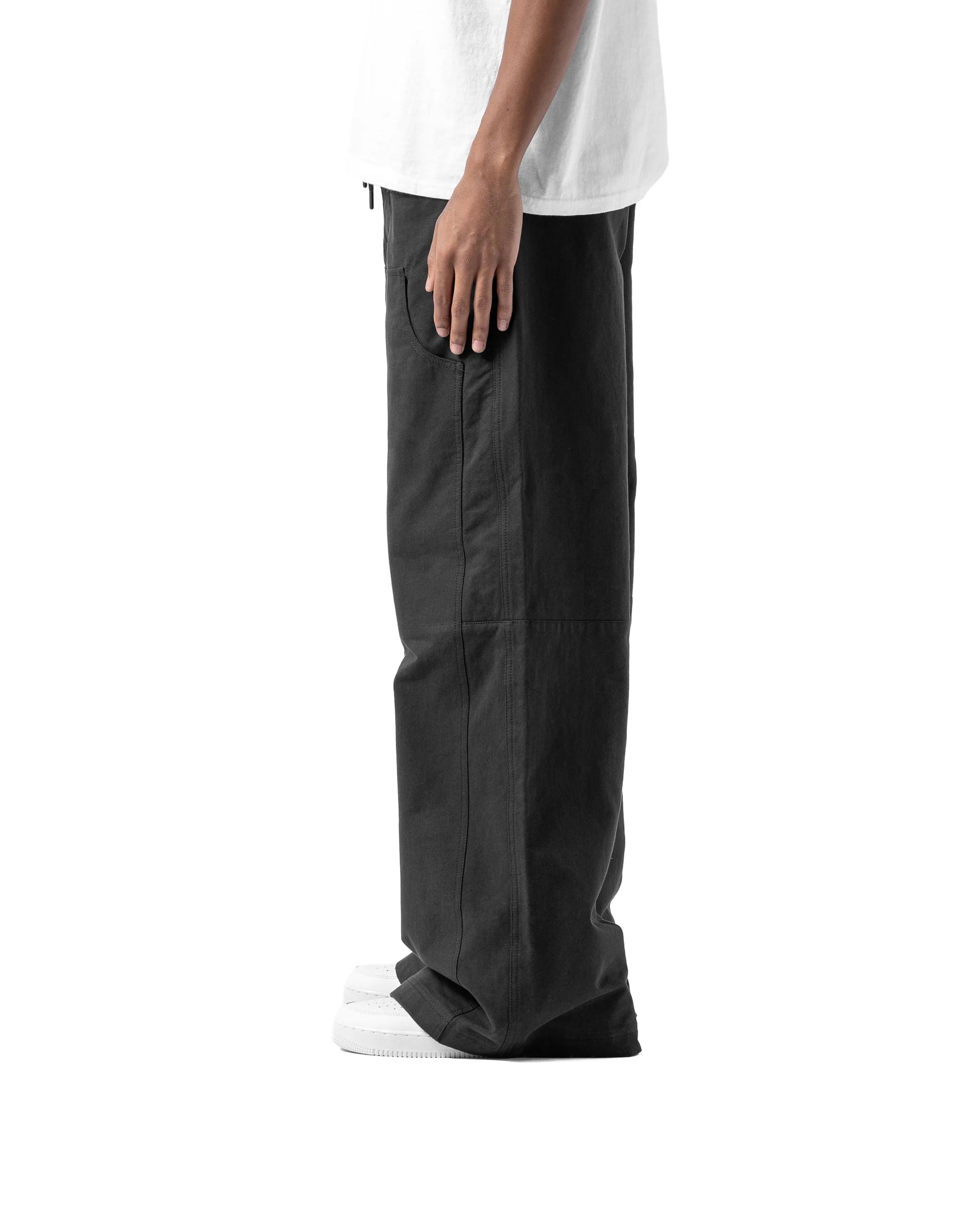 Person wearing black pants and a white shirt on a white background