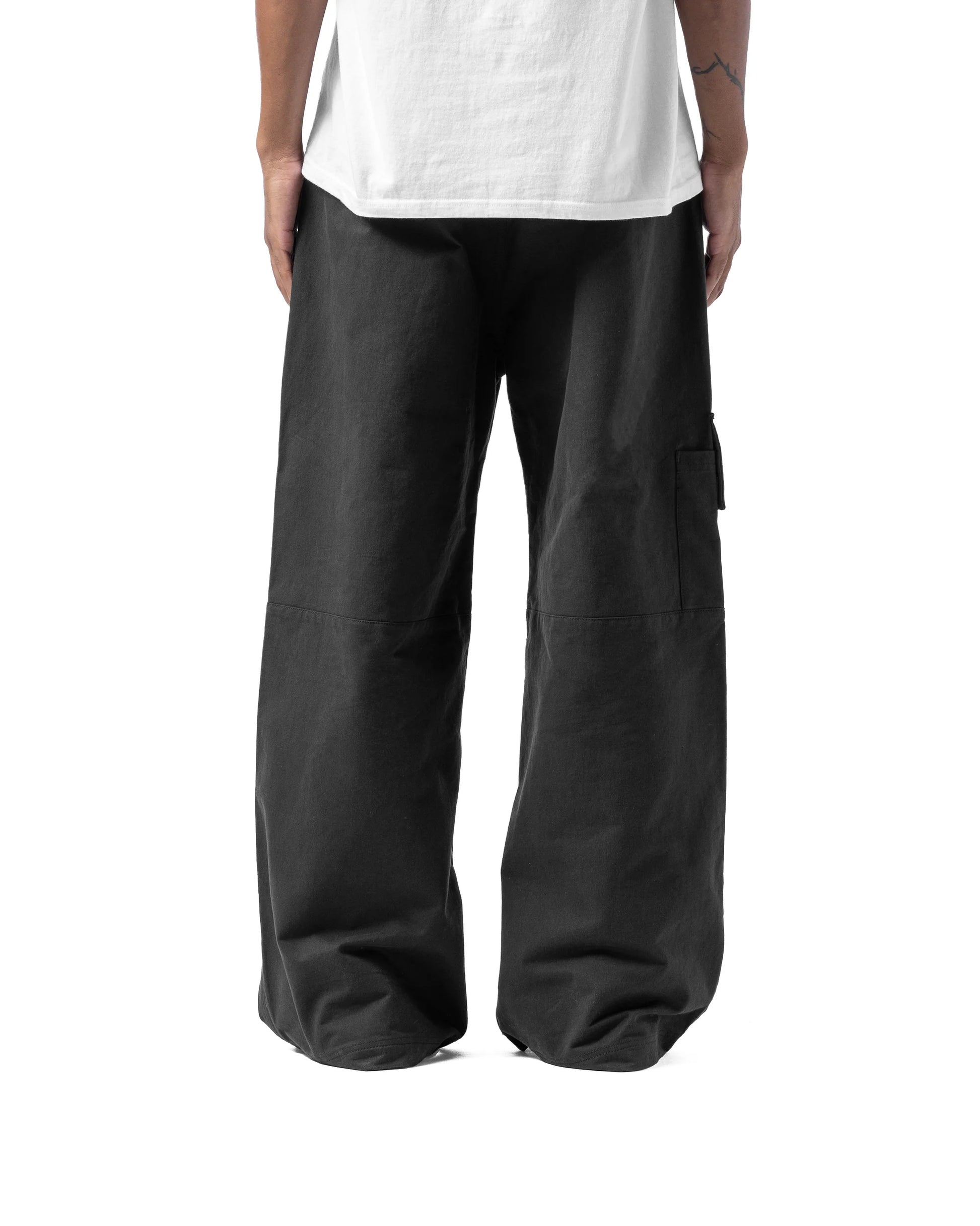 Person wearing black wide-leg pants and a white t-shirt on a white background