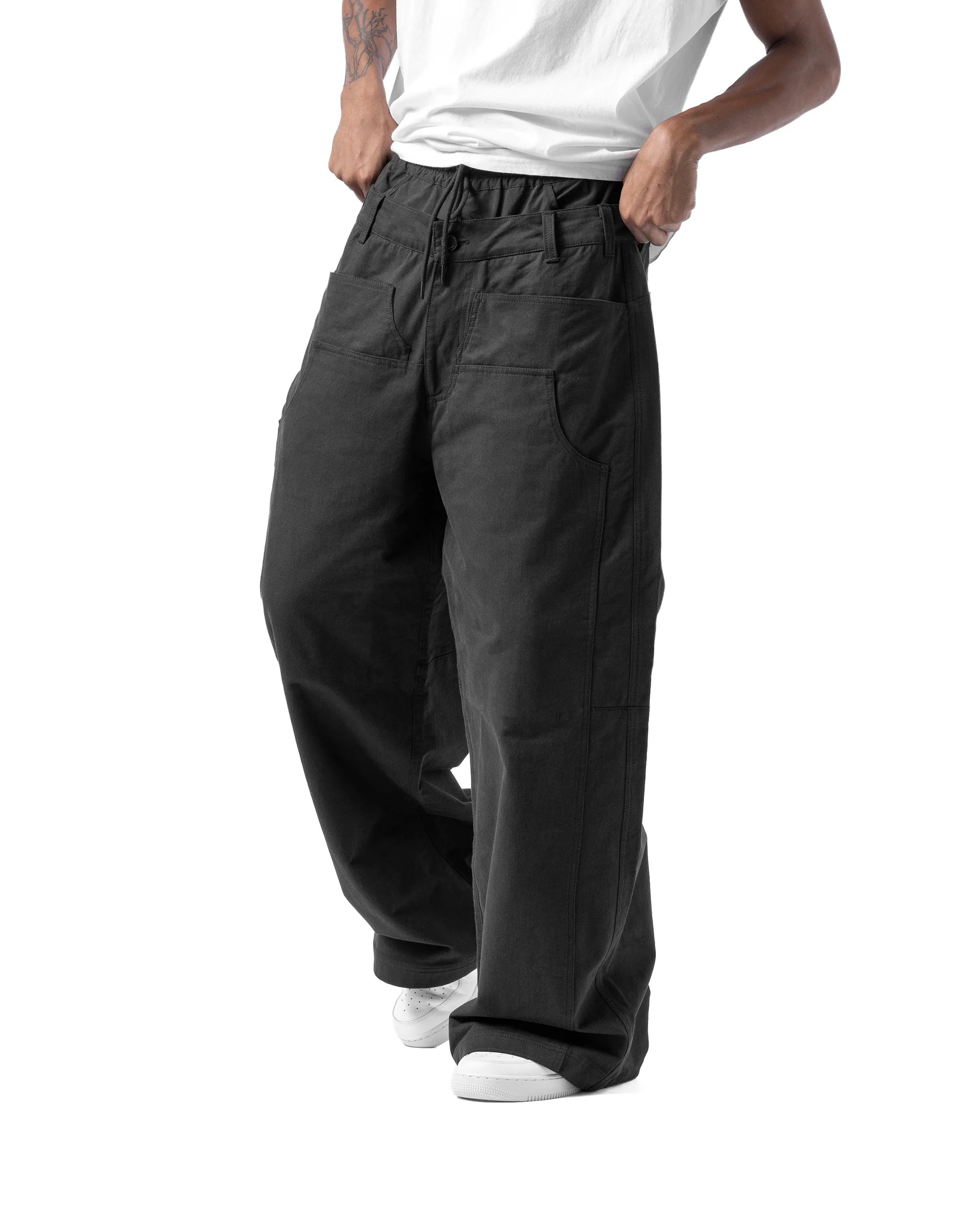 Person wearing black wide-leg pants on a white background