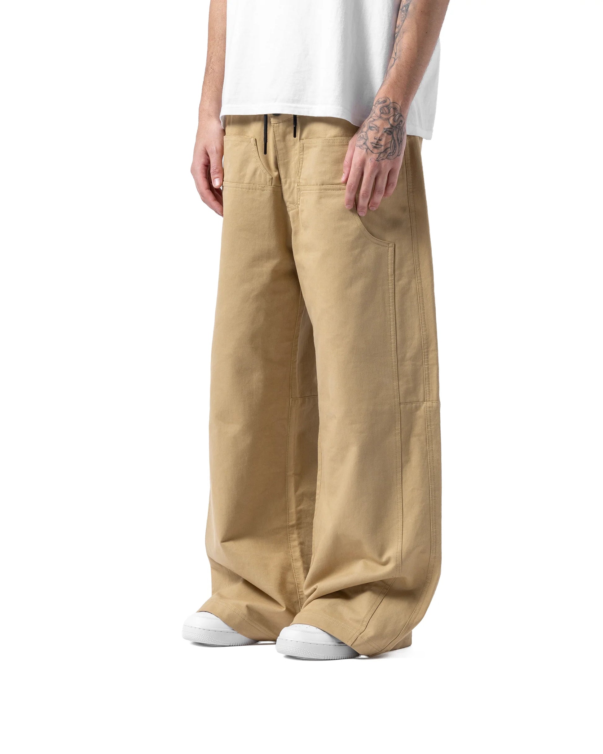 Person wearing beige cargo pants and a white shirt on a white background