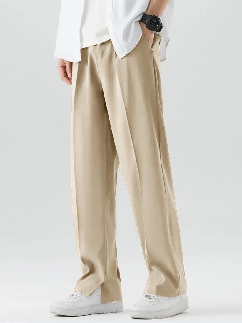 A person wearing Beige Tek Air loose fit pants and a white shirt, standing against a white background.