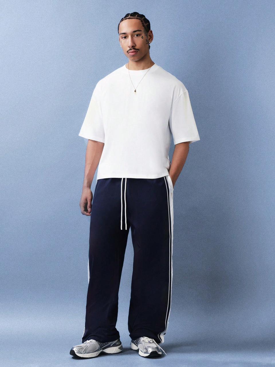 Navy blue pants with white drawstring on a plain background