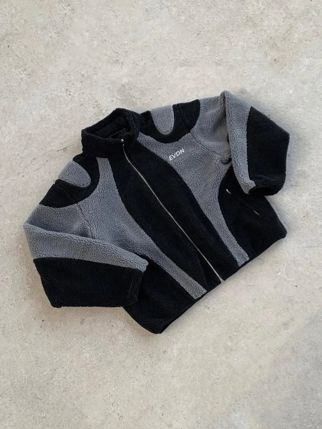 Black and gray fleece jacket on a light gray background