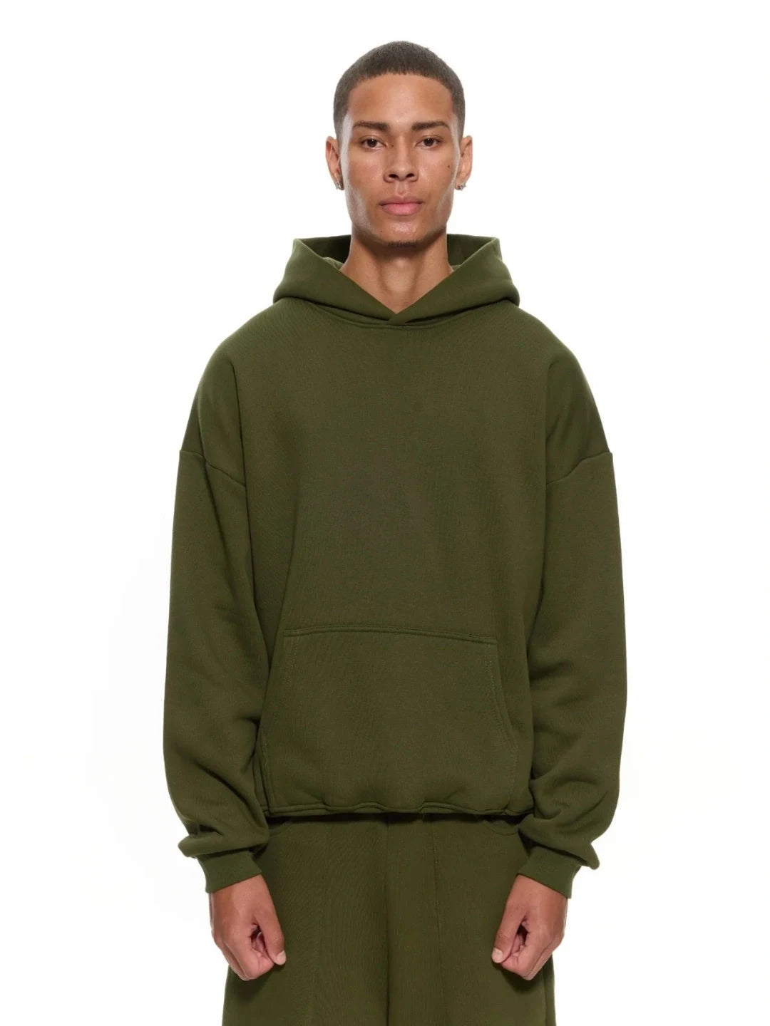 Person wearing an olive green hoodie on a white background