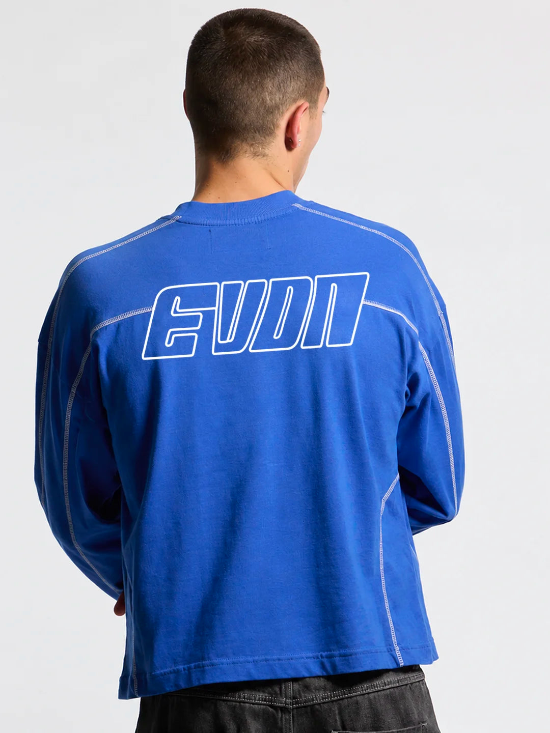 Person wearing a blue long-sleeve t-shirt with white accents and EVDN branding