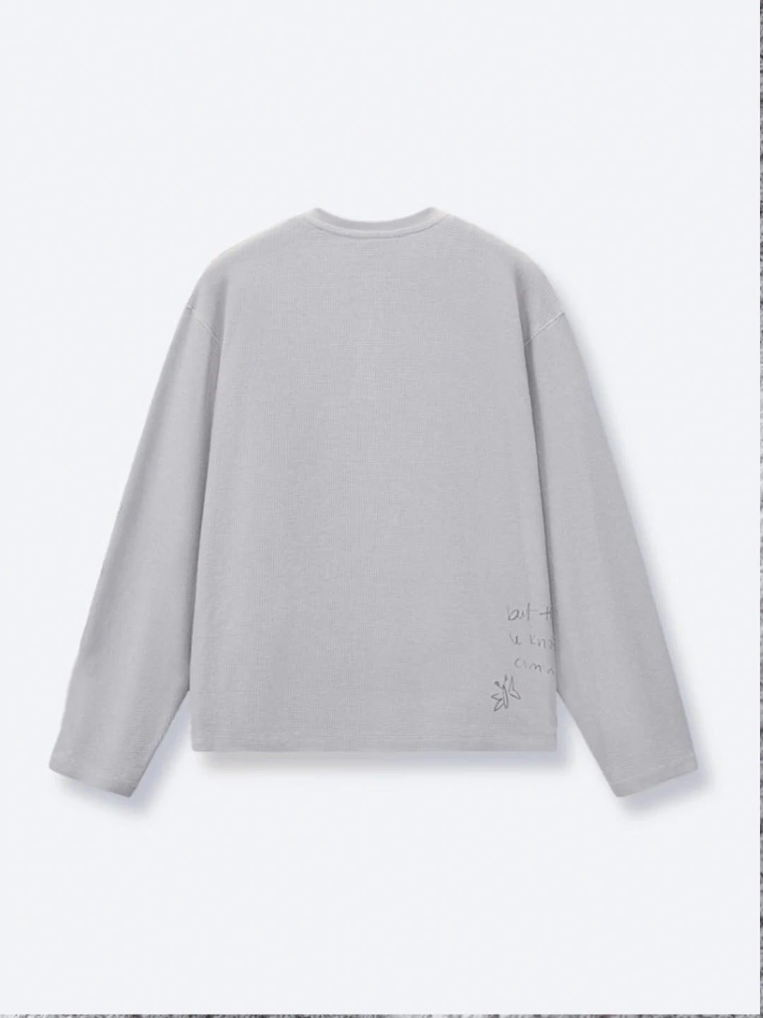 A light grey long-sleeve crewneck tshirt , featuring a small black graphic print near the lower right side of the back.