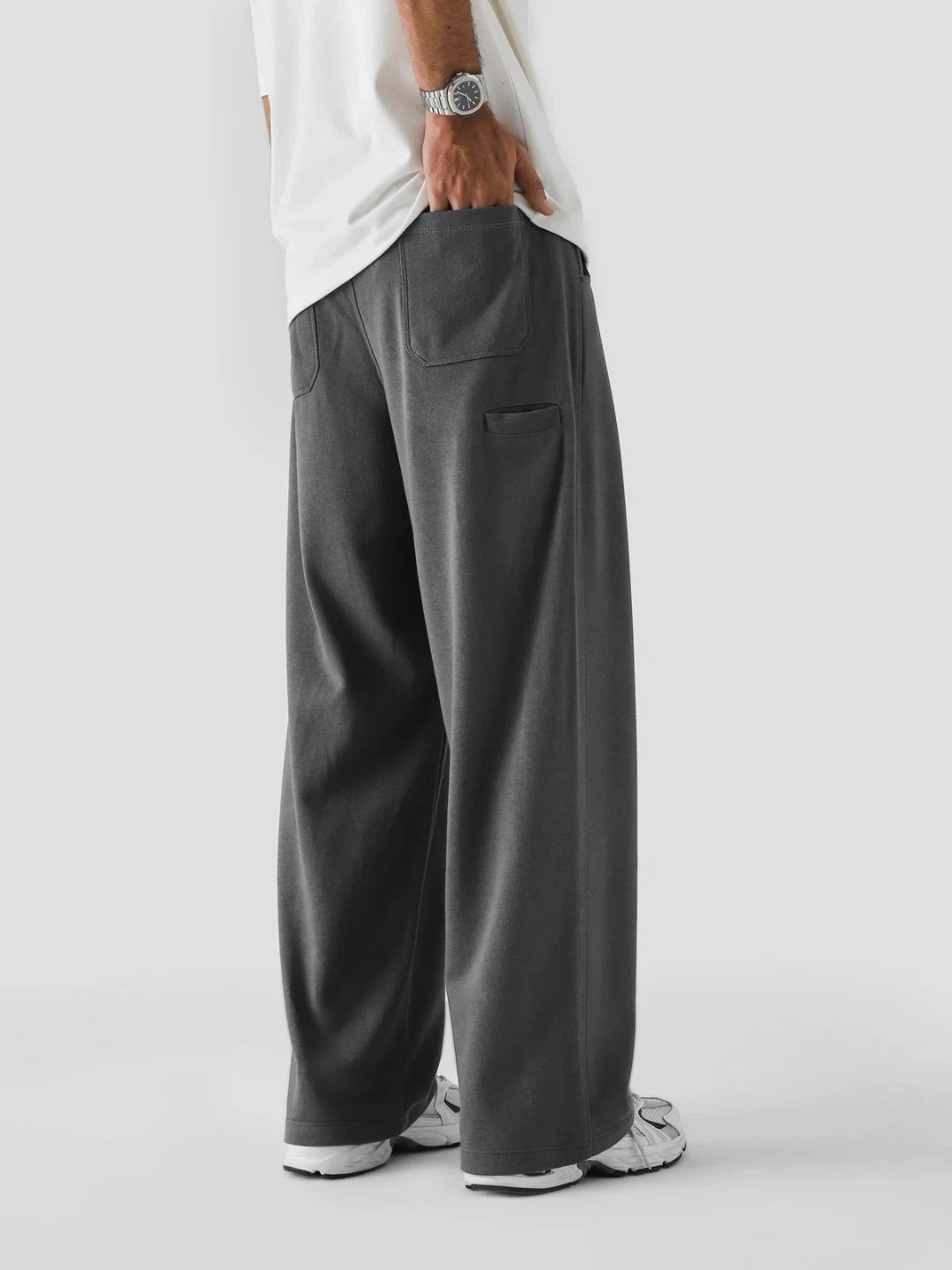 Person wearing grey wide-leg pants on a white background