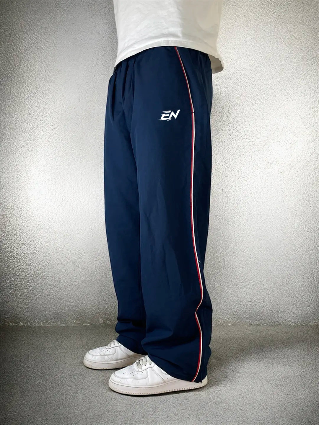 Navy tracksuit pants with a logo on a plain background
