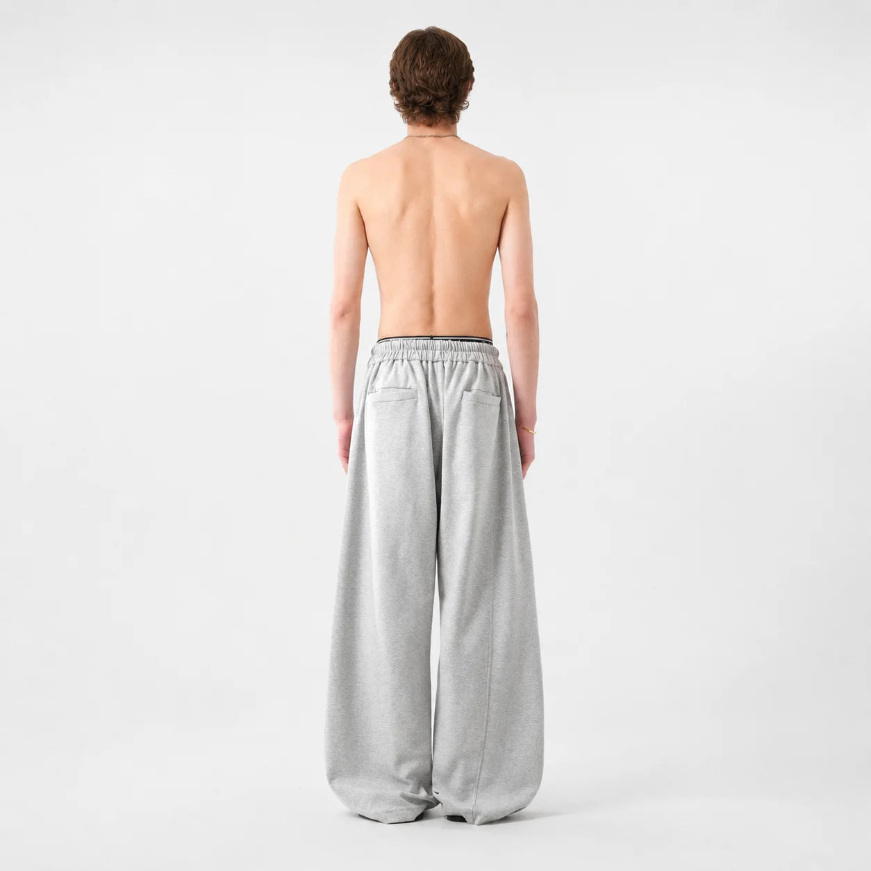 Person wearing light grey wide-leg pants on a white background