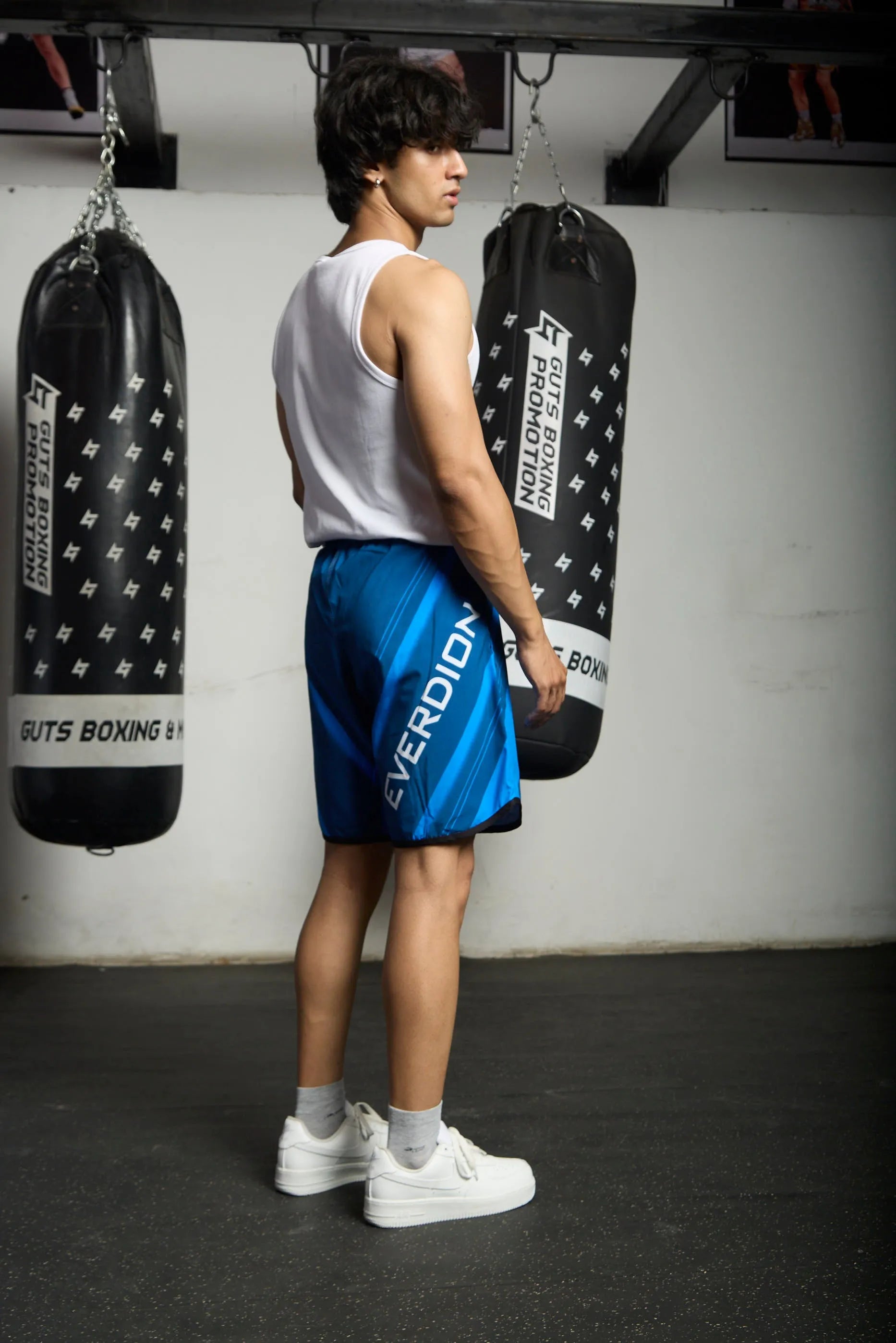 Person wearing blue Upshift MMA Shorts with Everdion logo