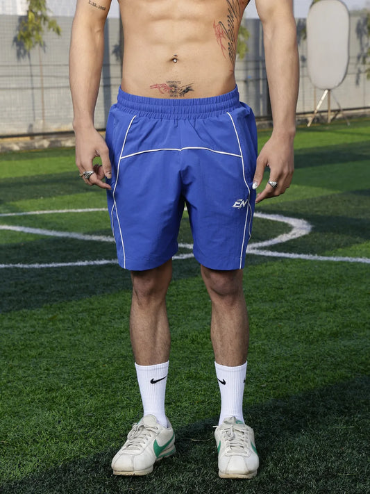 Person wearing blue athletic shorts on a grassy field