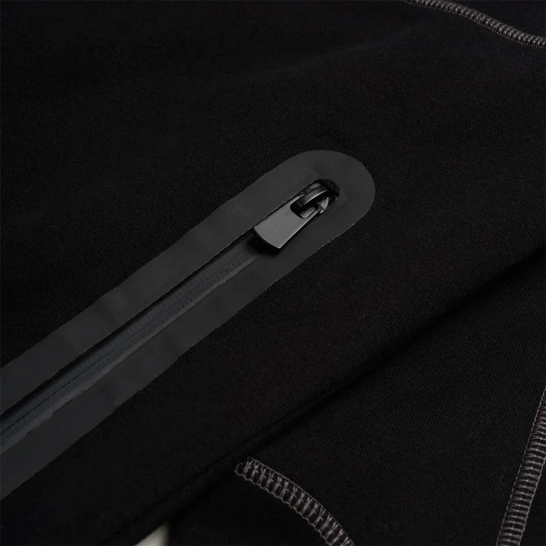 Close-up of a black zipper on a dark fabric surface