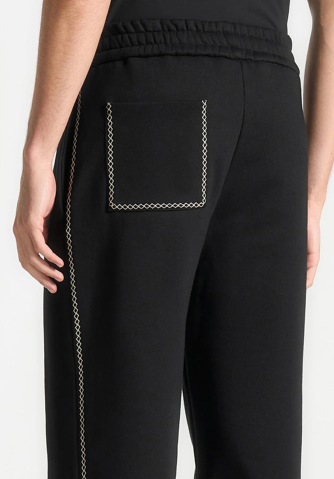 Black pants with a pocket detail on a white background