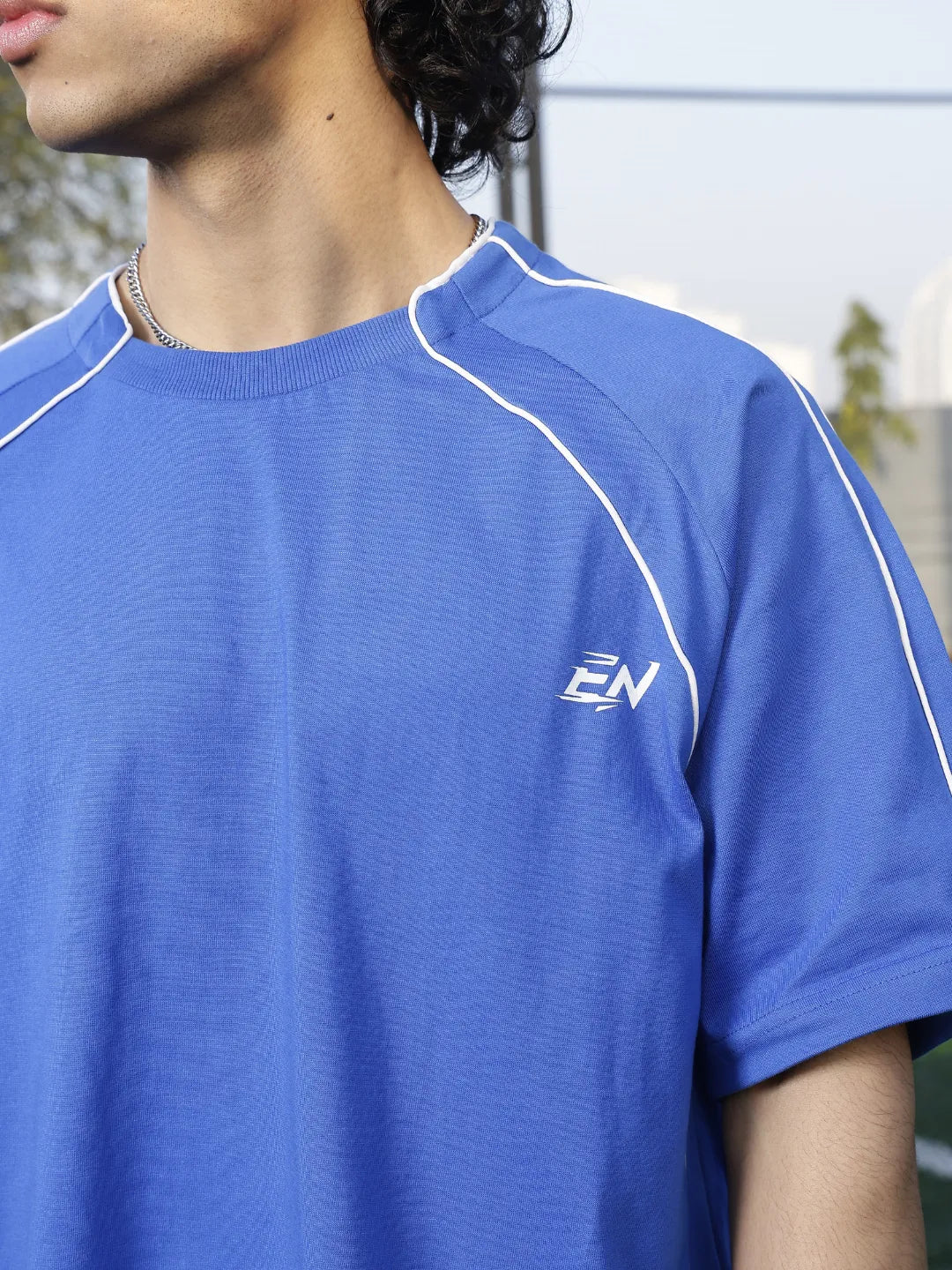 Person wearing a blue sports t-shirt  on a sports field