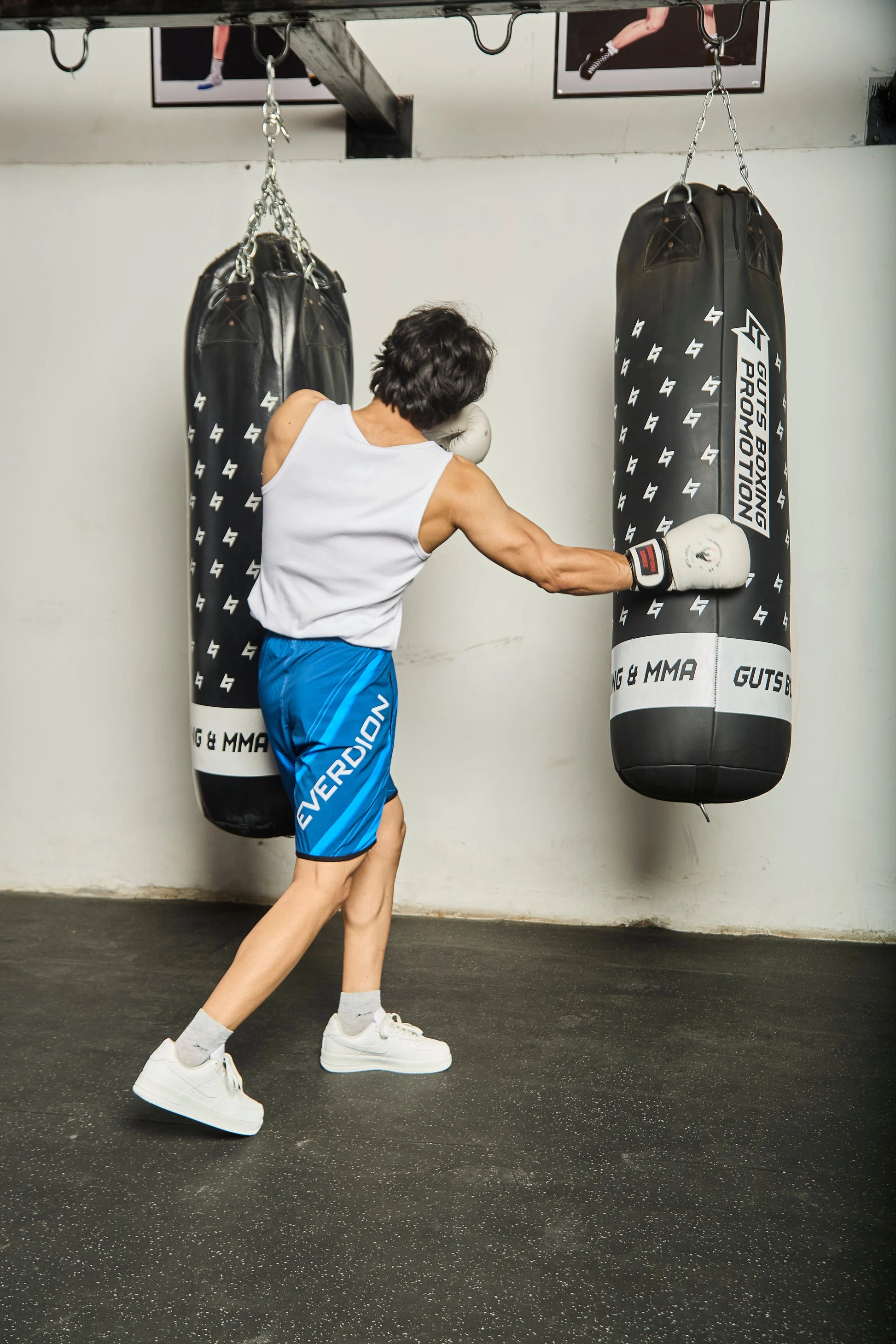 Person wearing blue Upshift MMA Shorts with Everdion logo