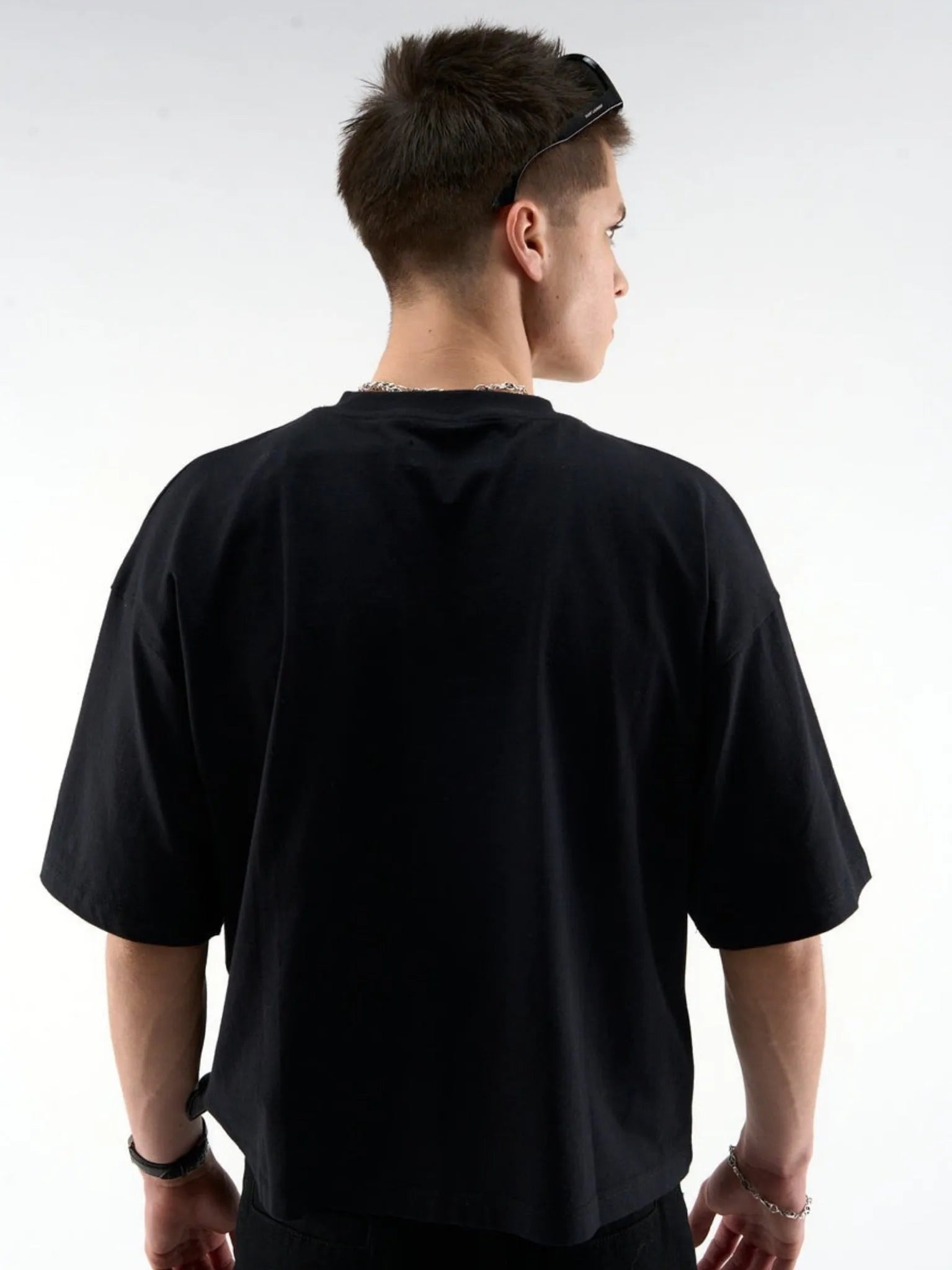 Person wearing a black t-shirt against a white background
