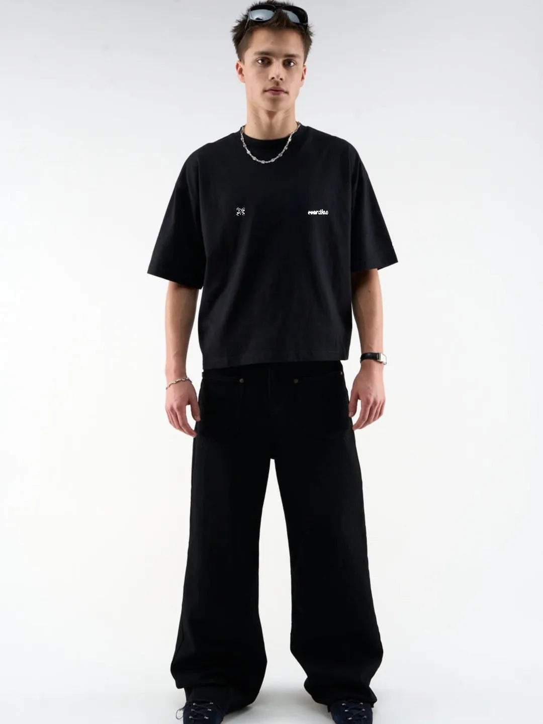 Person wearing a black t-shirt and pants on a white background
