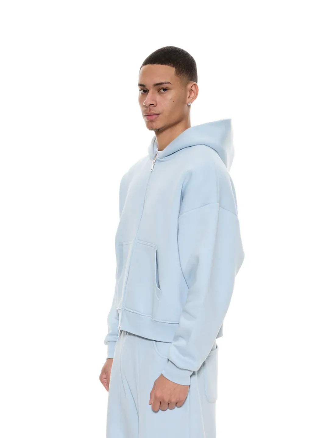 Person wearing a light blue zip-up jacket on a white background