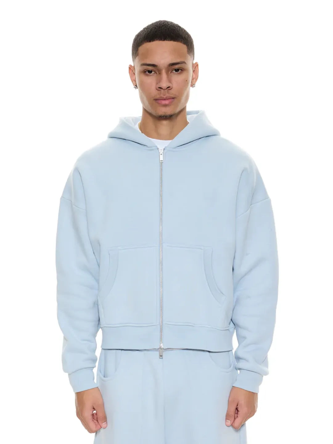 Person wearing a light blue zip-up jacket on a white background