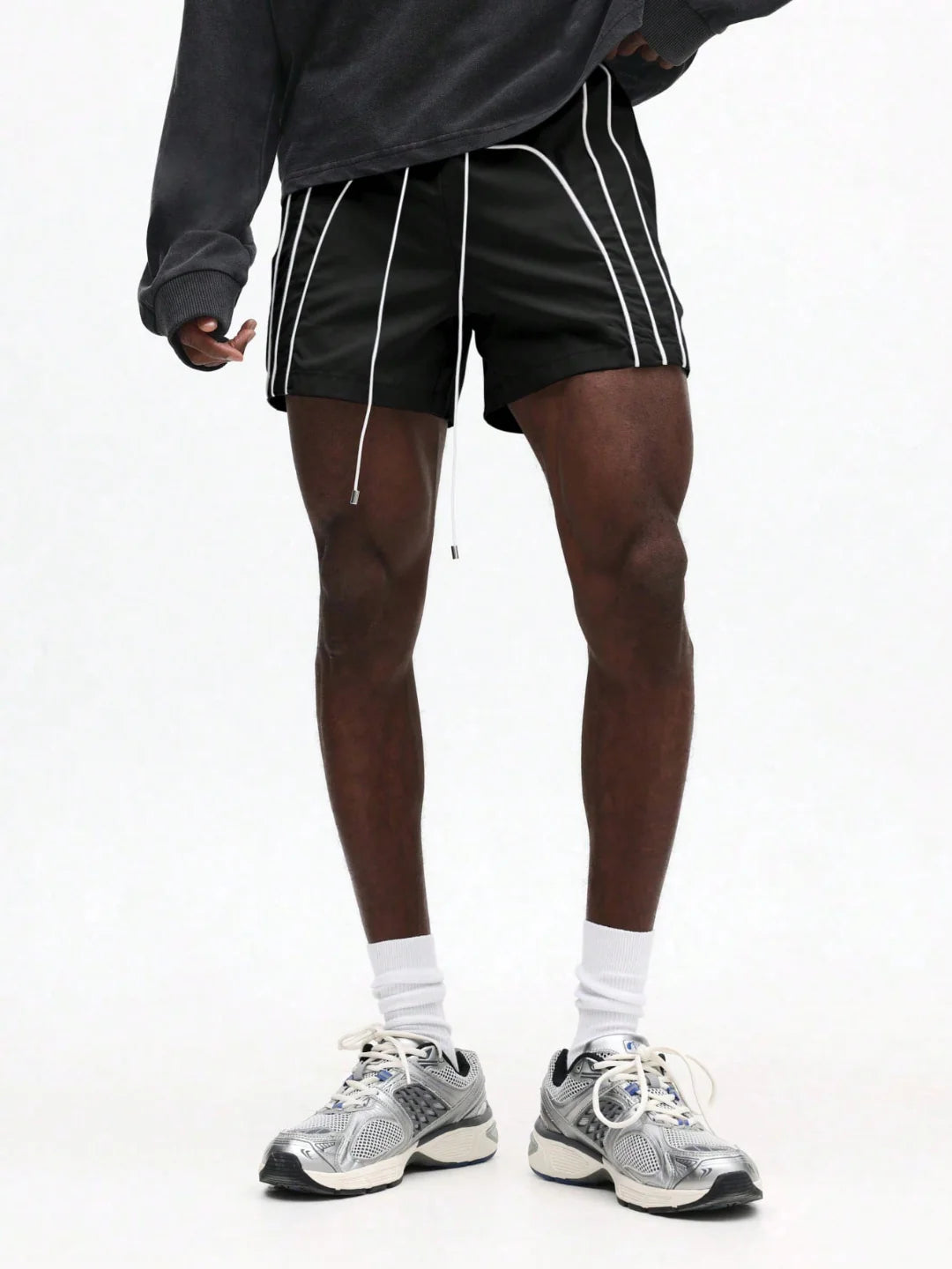 Person wearing black shorts with white stripes