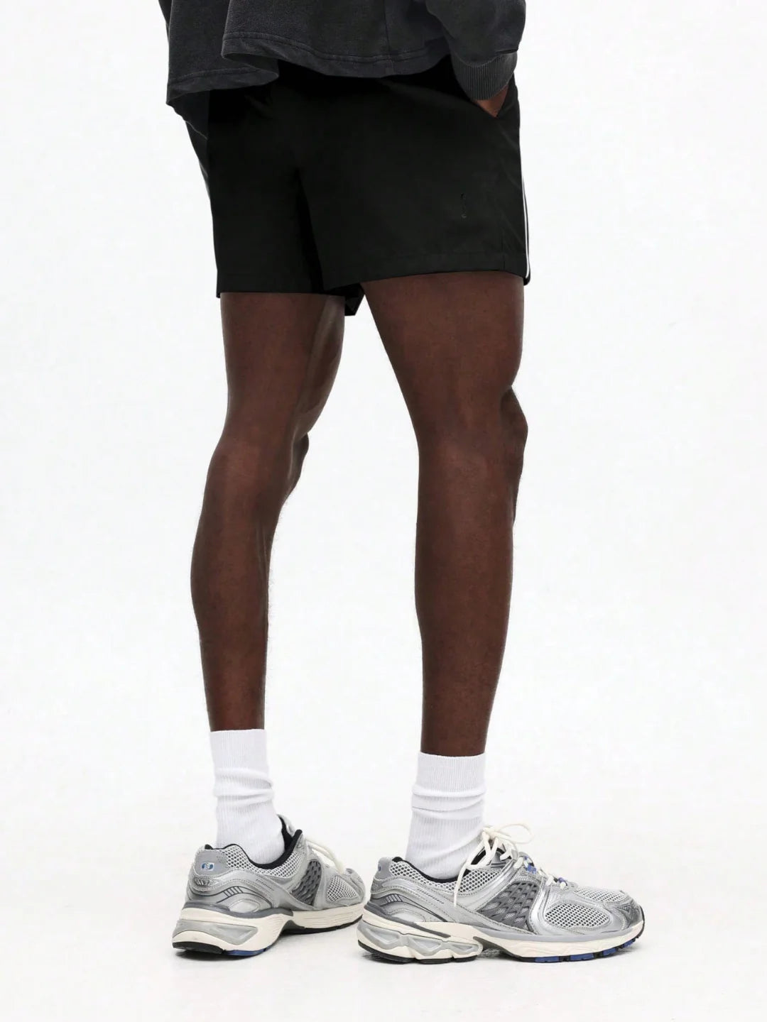 Person wearing black shorts with white stripes