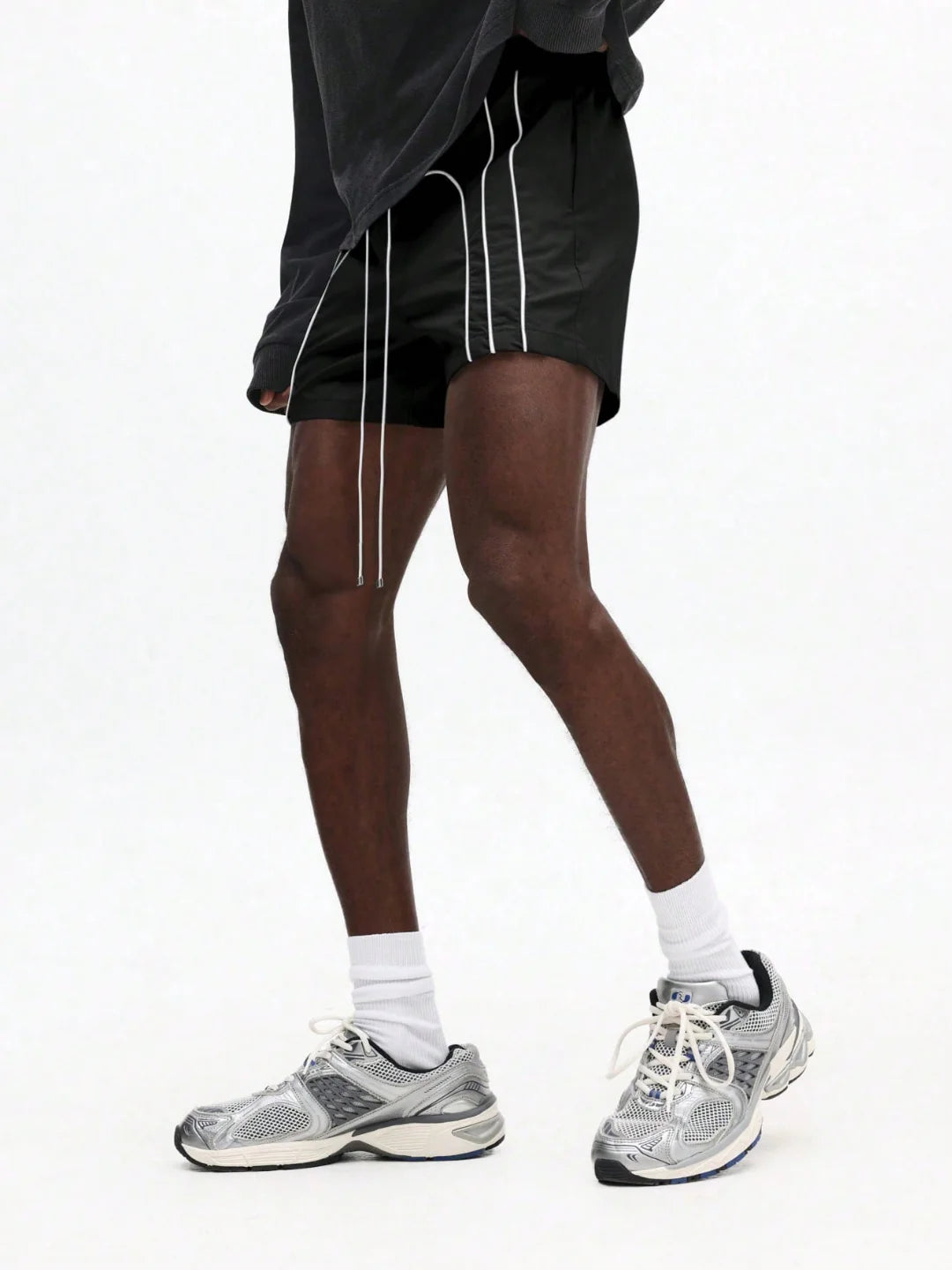 Person wearing black shorts with white stripes