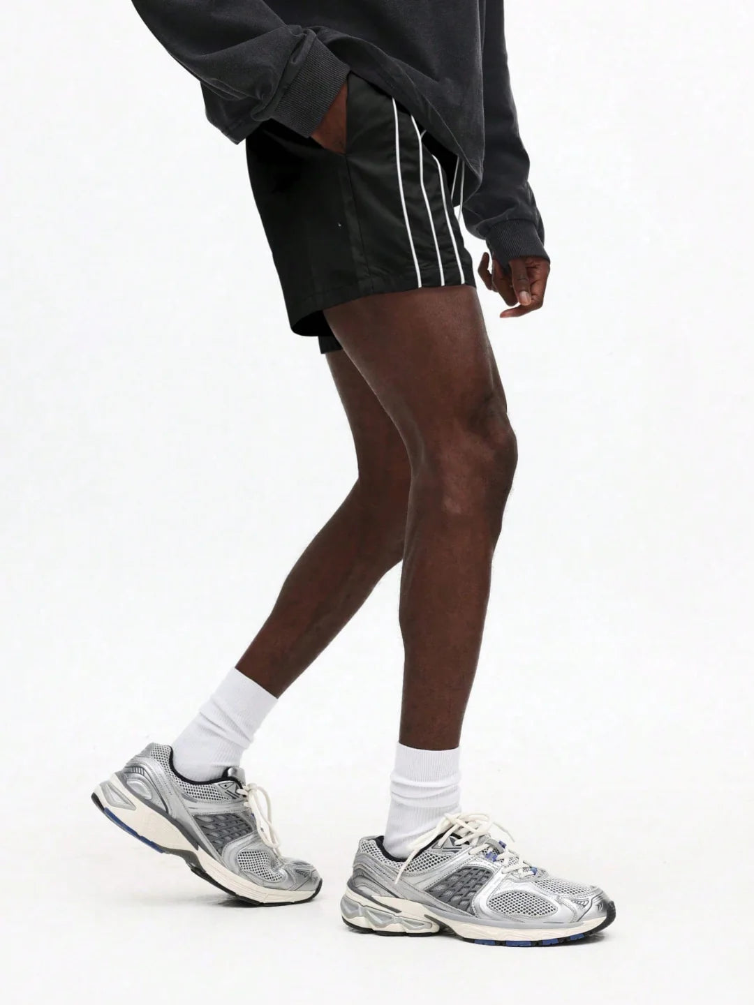 Person wearing black shorts with white stripes