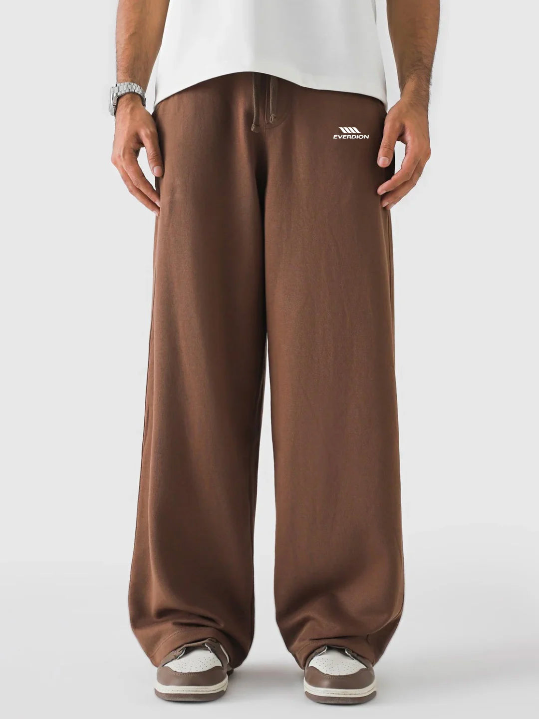 Brown sweatpants worn by a person on a white background