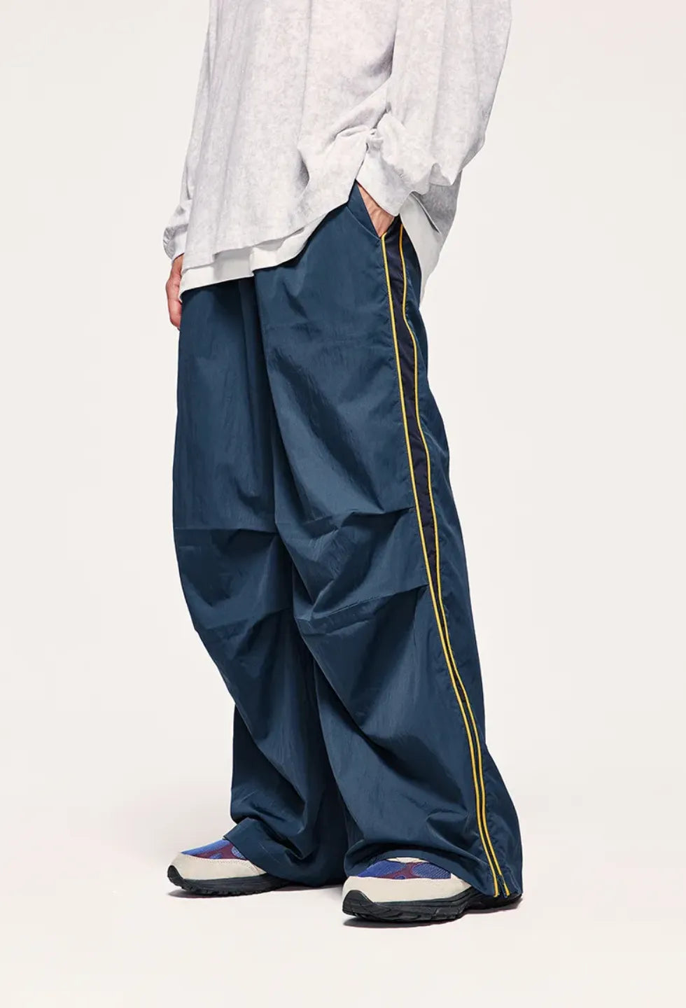 Person wearing blue pants with a yellow stripe on a white background
