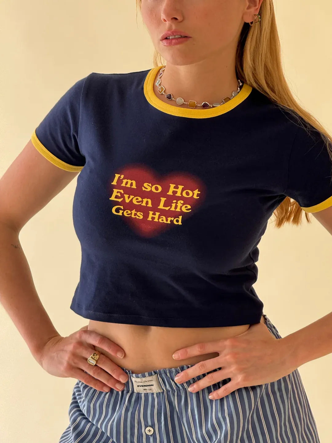 Person wearing a navy blue t-shirt with yellow text on a beige background