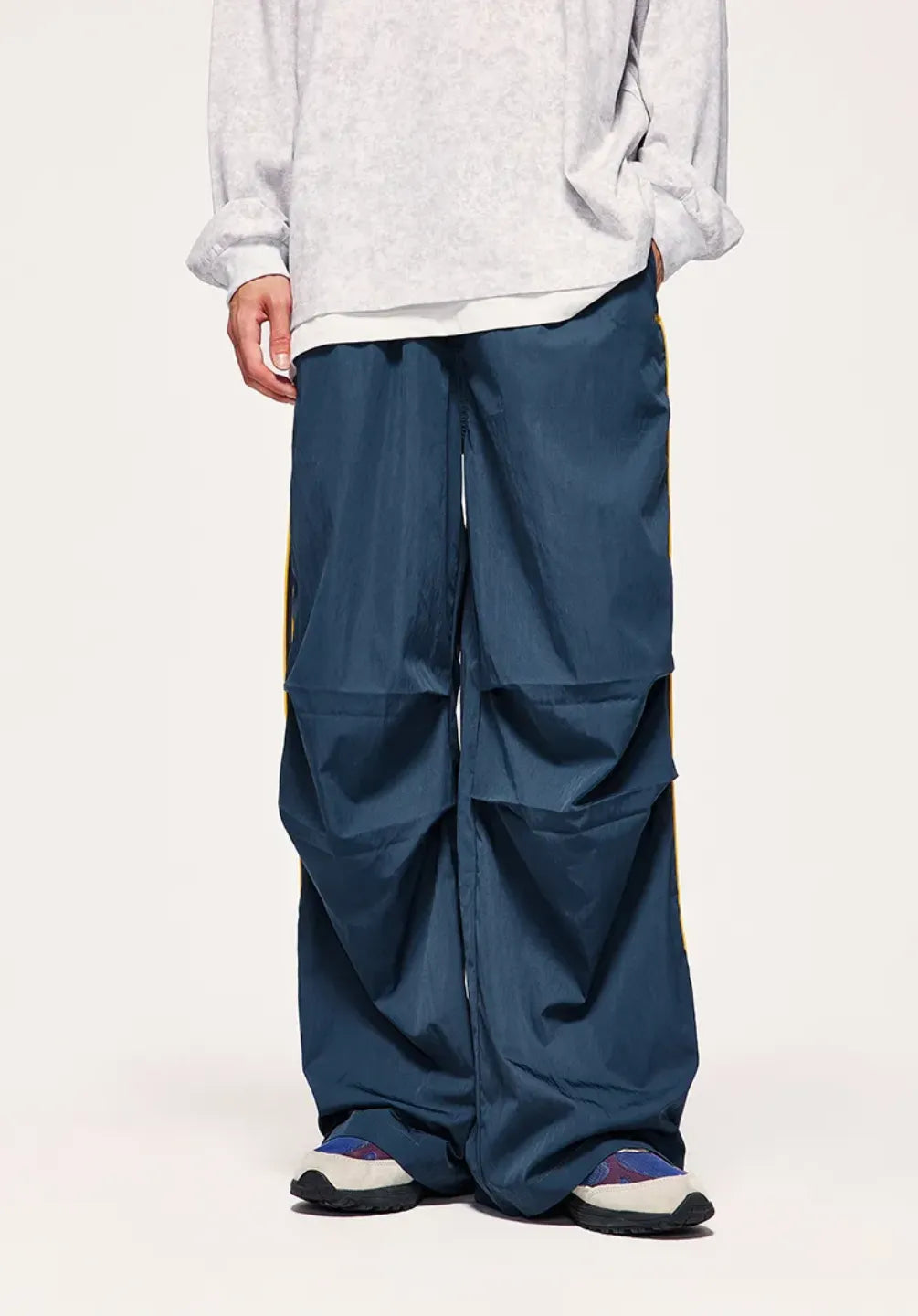 Person wearing a white shirt and blue layered pants on a white background