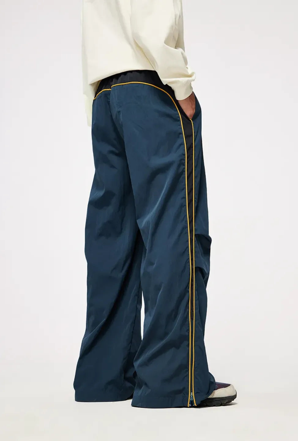 Person wearing blue pants with a gold zipper on a white background