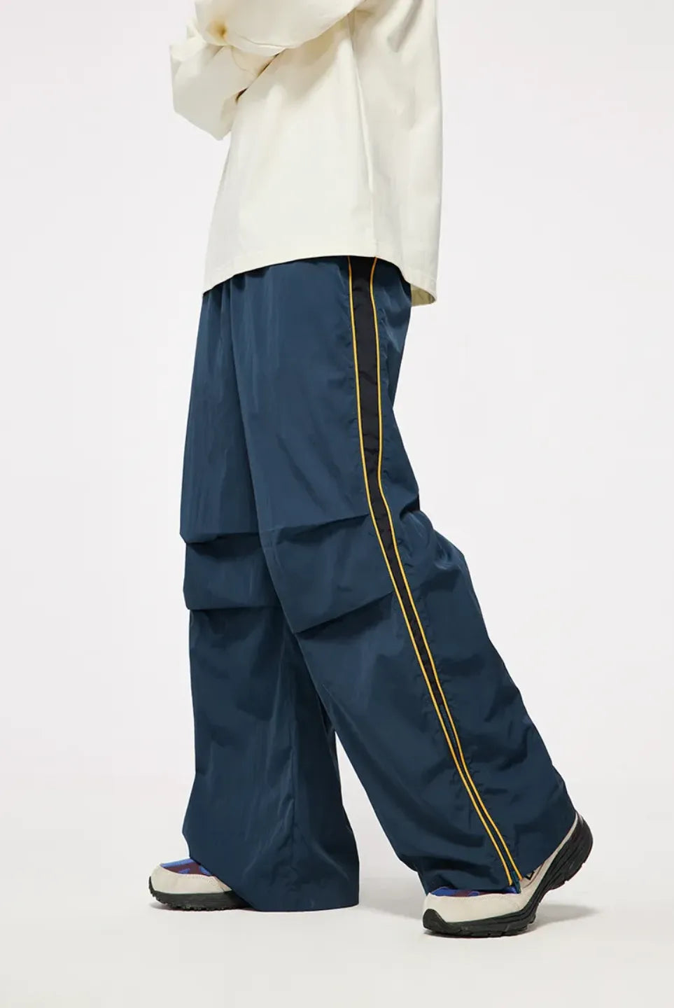 Person wearing blue pants with yellow piping on a white background