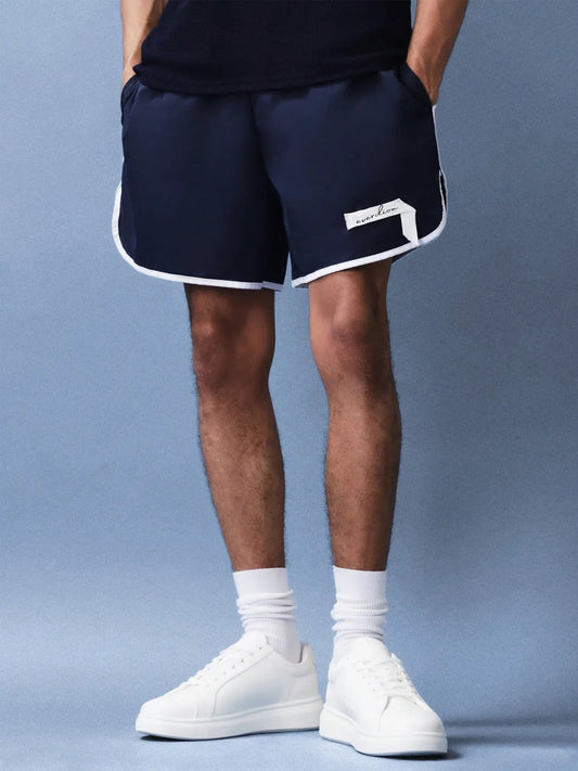Person wearing navy shorts with a brand logo on a blue background