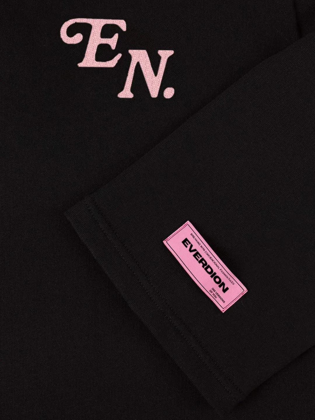 Black garment with pink 'EN' initials and Everdion label on a dark background