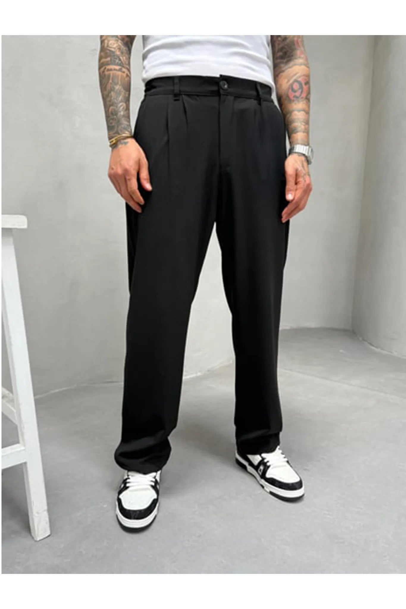 Person wearing black pleated office pants 
