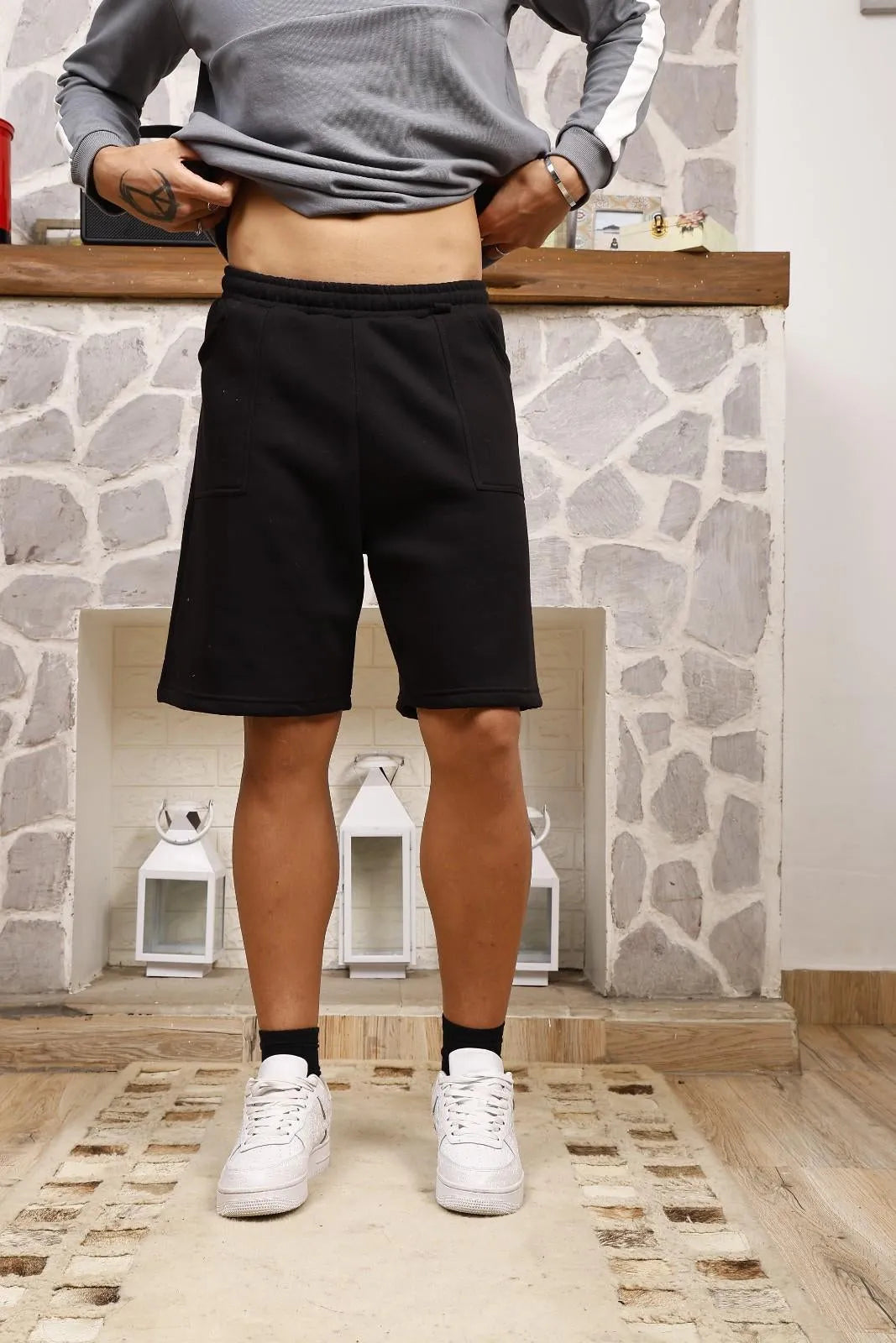 Person wearing black sweat shorts 