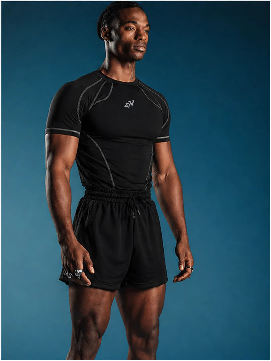 Man wearing a black athletic t-shirt with a logo on a blue background
