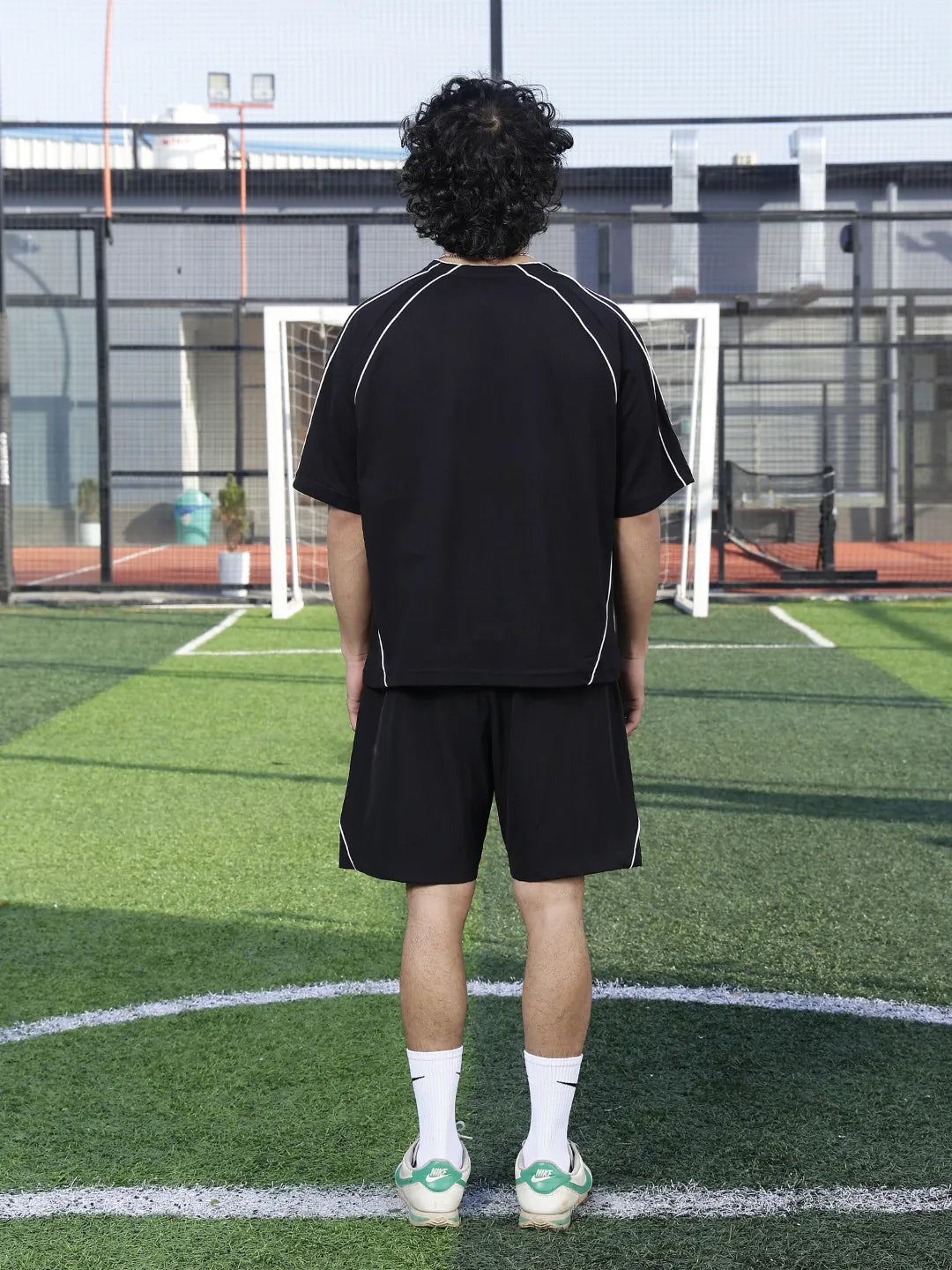 Person wearing a black sports outfit on a grassy field